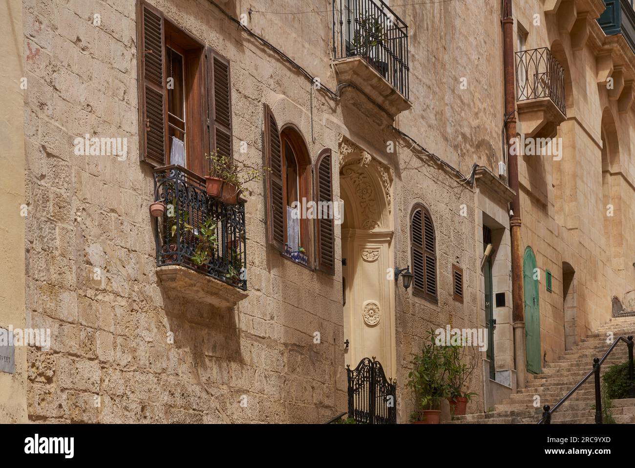 Historic buildings lining narrow streets in the city of Valetta in Malta Stock Photo