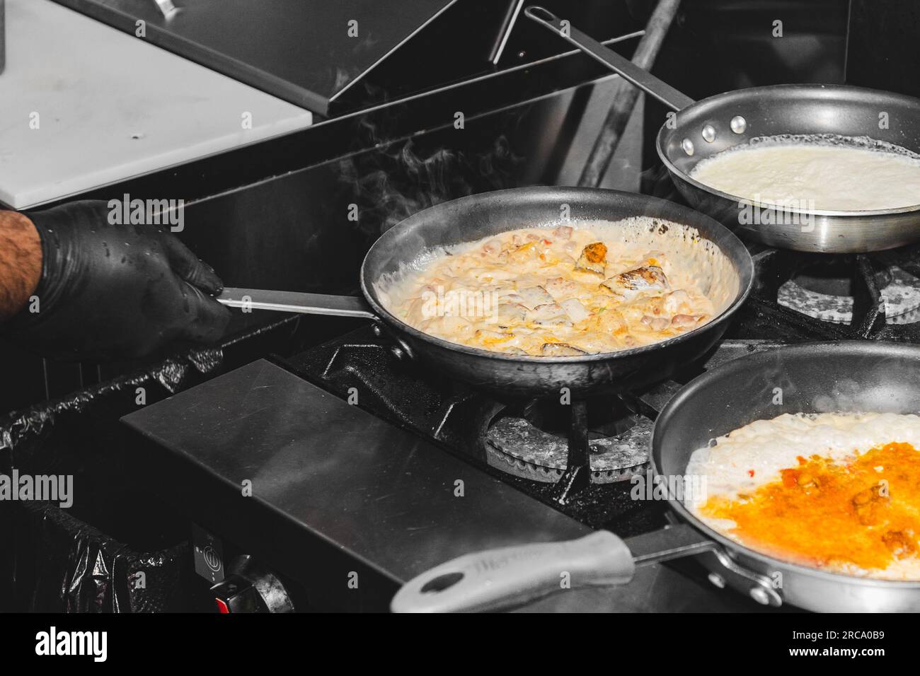 Risotto food cooking in a pan on a stove with a hand shaking the pan Stock Photo Alamy