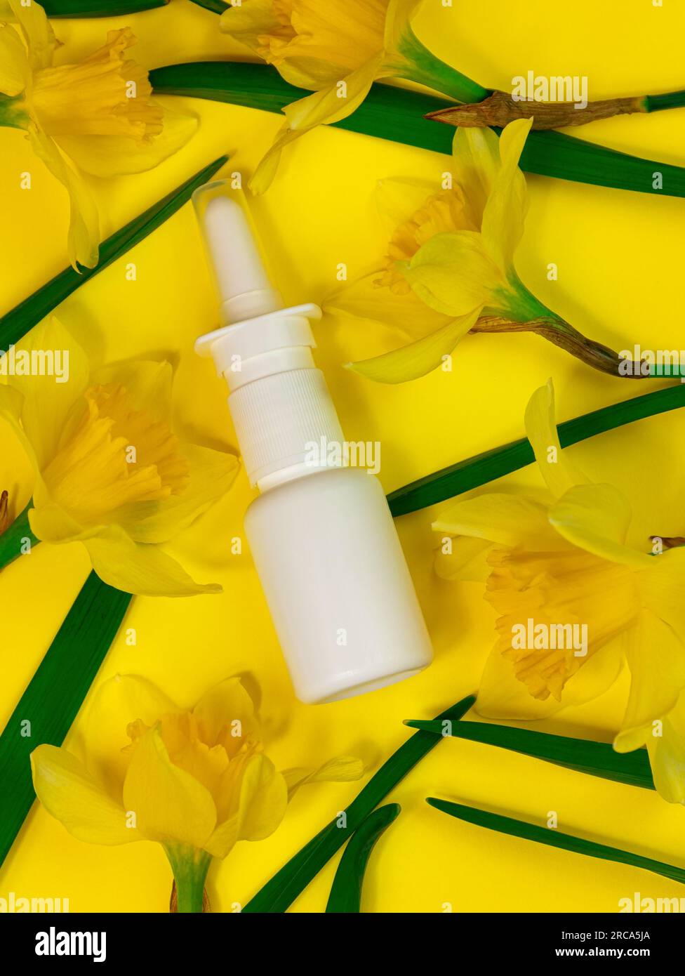White medical nasal spray bottle mockup on yellow background flat lay