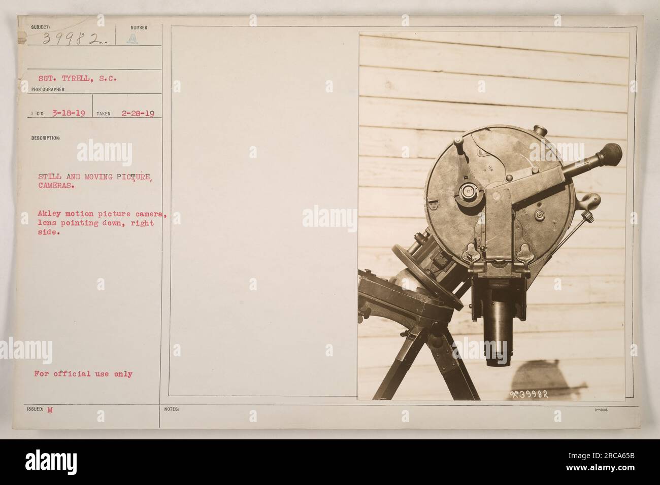 Image shows a still and moving picture camera, specifically the Akely motion picture camera, with the lens pointed downward on the right side. This equipment was used by Sgt. Tyrell, S.C. photographer during World War I. The photo was taken on 2/28/1919. Stock Photo