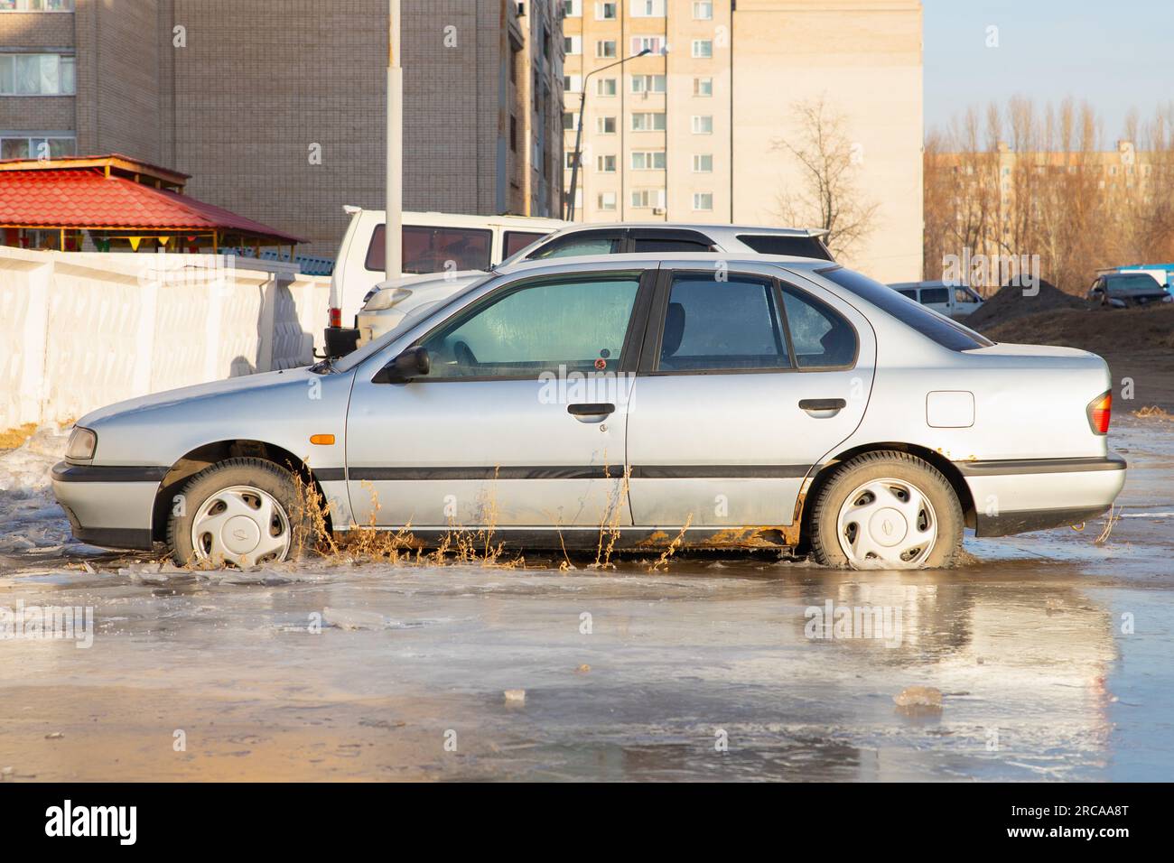 old Nissan Primera car in frozen water. winter accident. front view. Pavlodar, Kazakhstan - 12.28.2022. Stock Photo