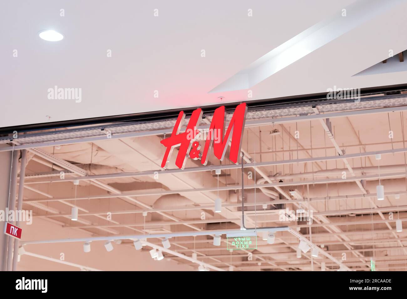 logo of Hennes and Mauritz, hm, H and M on ceiling. Pavlodar, Kazakhstan - 12.28.2022 Stock Photo