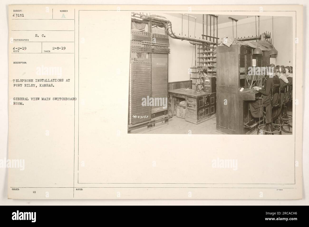Image shows a general view of the main switchboard room at Fort Riley, Kansas. The photograph was taken on February 8th, 1919, for the purpose of documenting telephone installations provided by the Signal Corps. This photo is part of the collection titled 'Photographs of American Military Activities during World War One.' Stock Photo