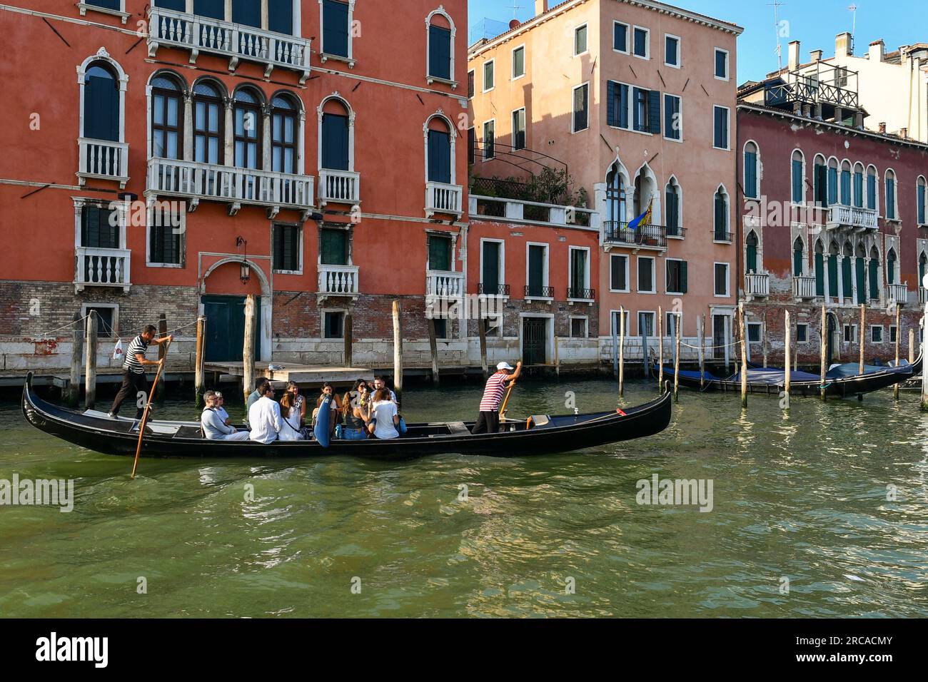 A group of tourists crossing the Grand Canal on a ferry gondola in front of Palazzo Giustinian Persico and Palazzo Tiepolo Passi, Venice, Italy Stock Photo