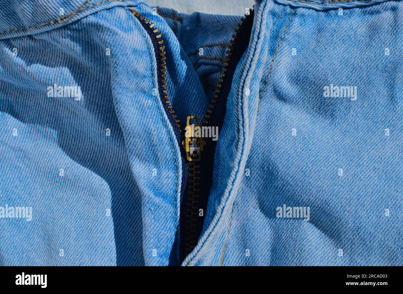 Jeans with zipper. Close-up of jeans stitching, highlighting tough and durable lines.000- Indispensable for projects related to fashion and clothing. Stock Photo