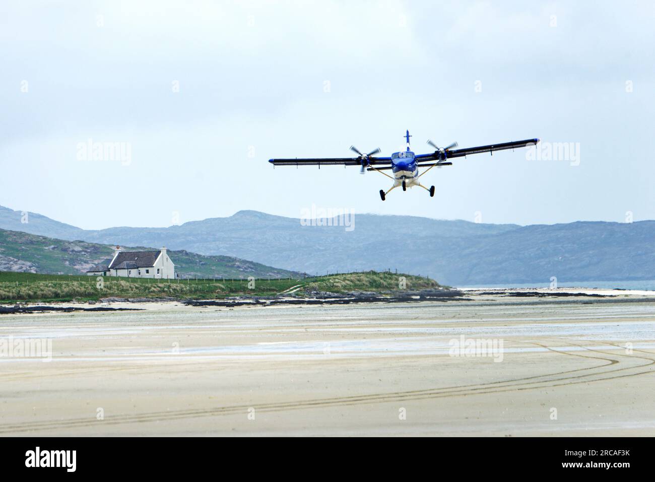 Barra Airport on Traigh Mhor beach at Ardmhor on north end of Barra, Outer Hebrides. Looking NE. Scheduled flight taking off from sands Stock Photo