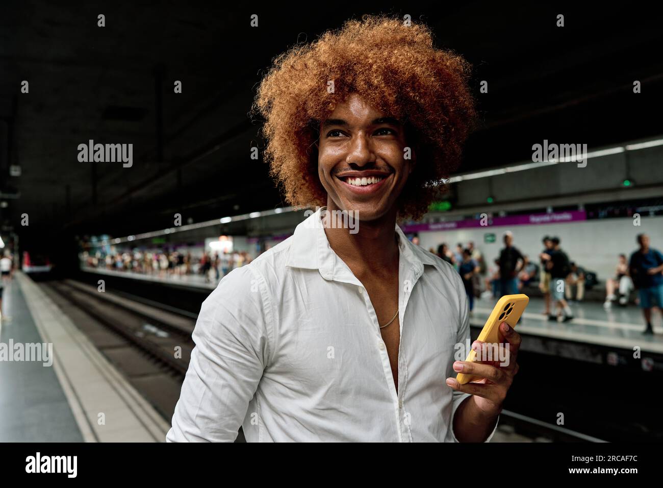 young afro hair latin man using smartphone in underground city metro - commute and clean transportation concept Stock Photo