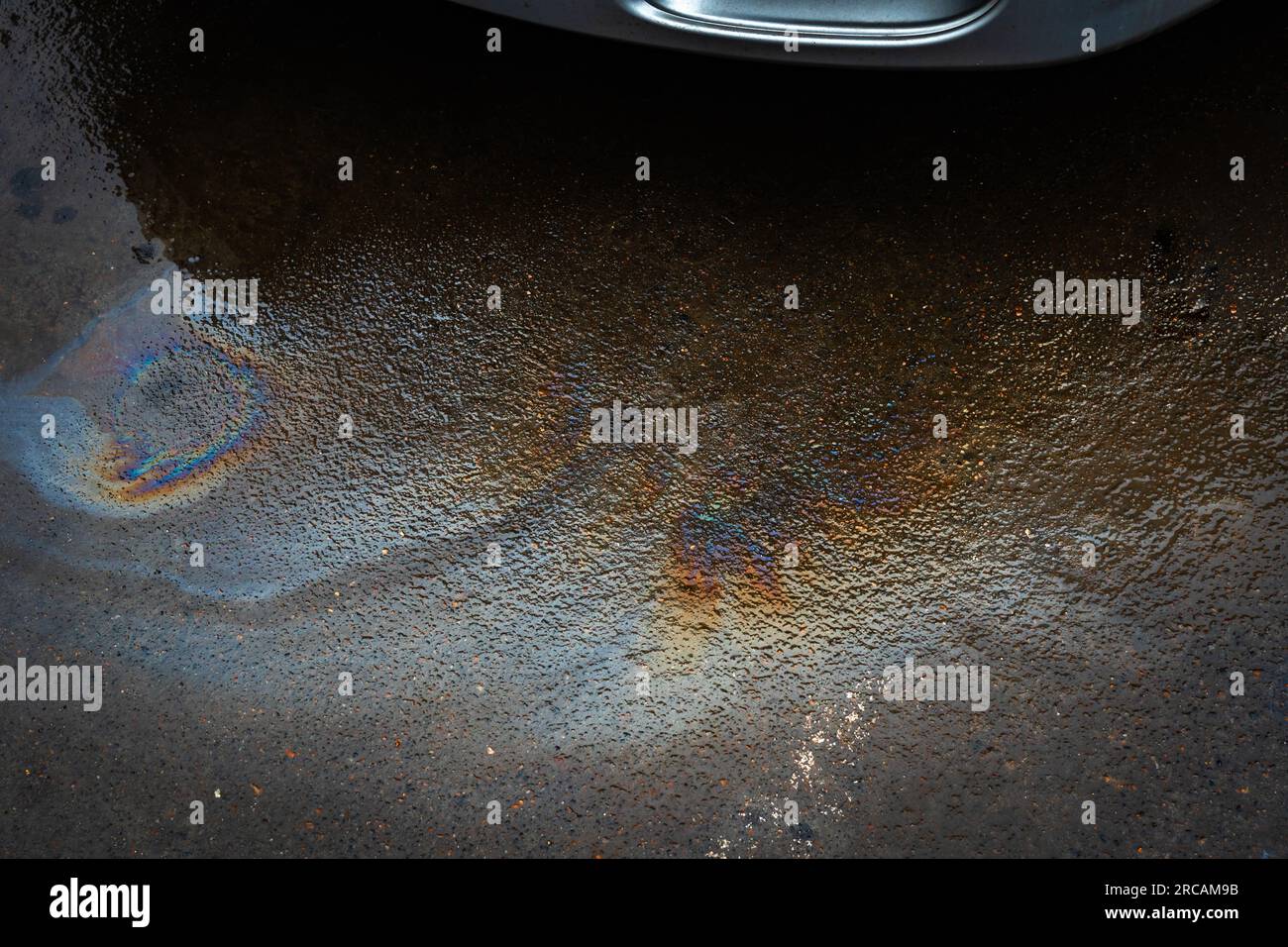 Oil stain or gasoline caused by a leak under a car. Environmental