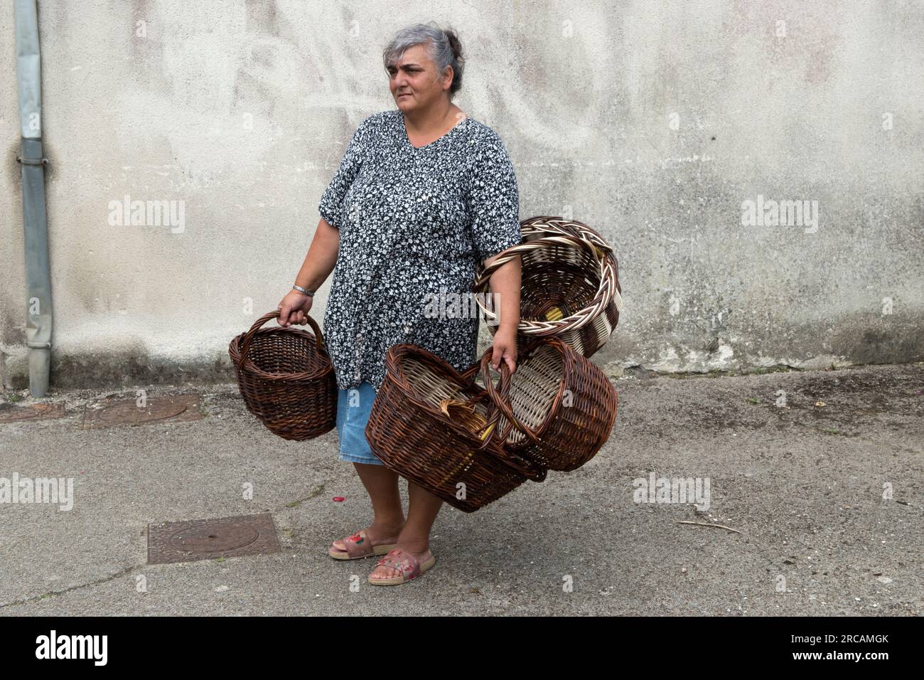 Roma Gypsy Woman France. French roma women selling handmade wicker baskets in the street at Saint Michel en Greve, Cotes-d'Armor, Brittany, France . 10th July 2023. 2020s HOMER SYKES. Stock Photo