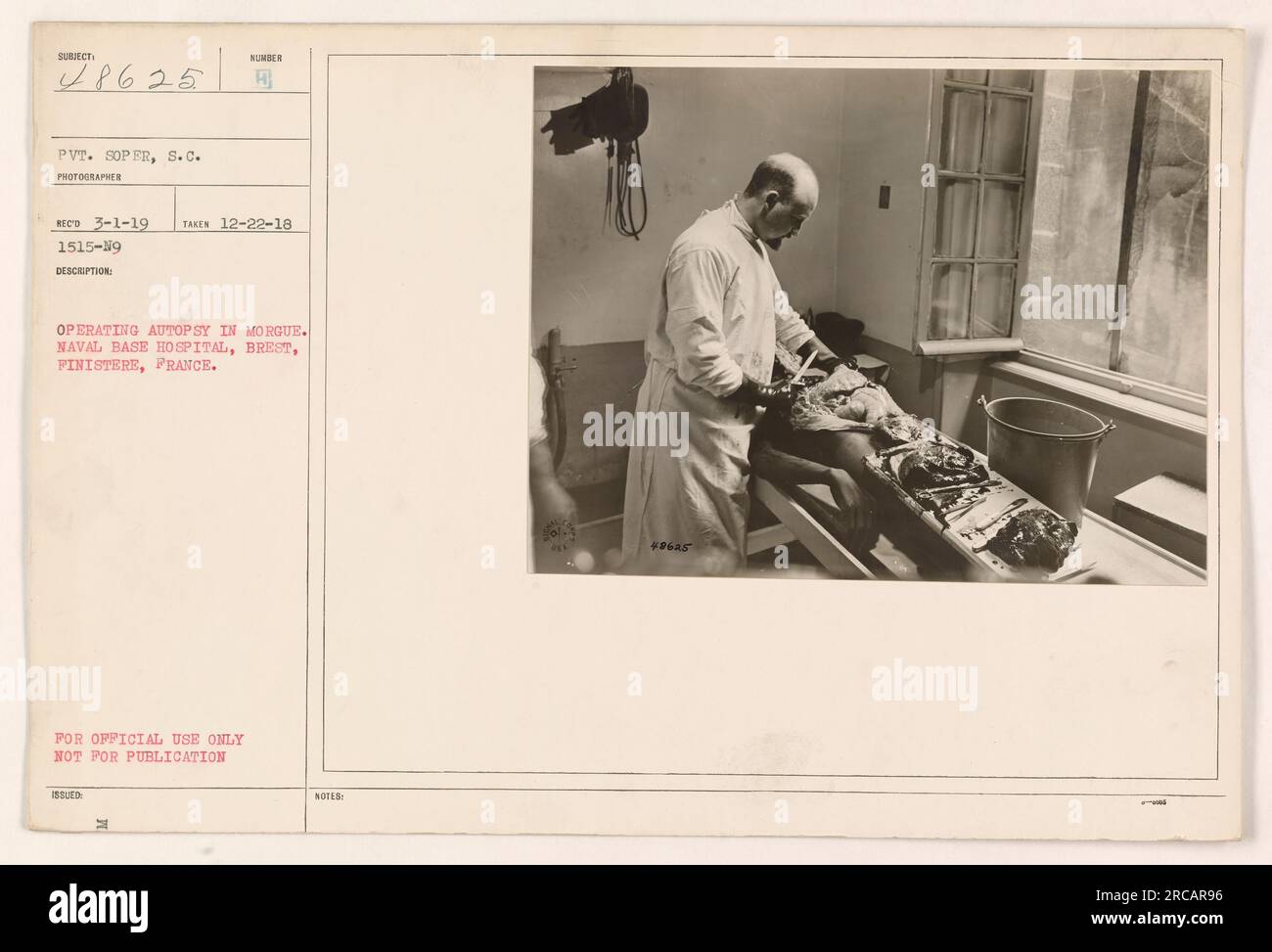 An autopsy being conducted at the morgue in Naval Base Hospital, Brest, Finistere, France. The photograph was taken by Pvt. S.C. Soper on 22nd December 1918. The image is labeled as 'Operating Autopsy in Morgue' and has the file number 1515-19. It is marked 'For Official Use Only, Not for Publication.' Stock Photo