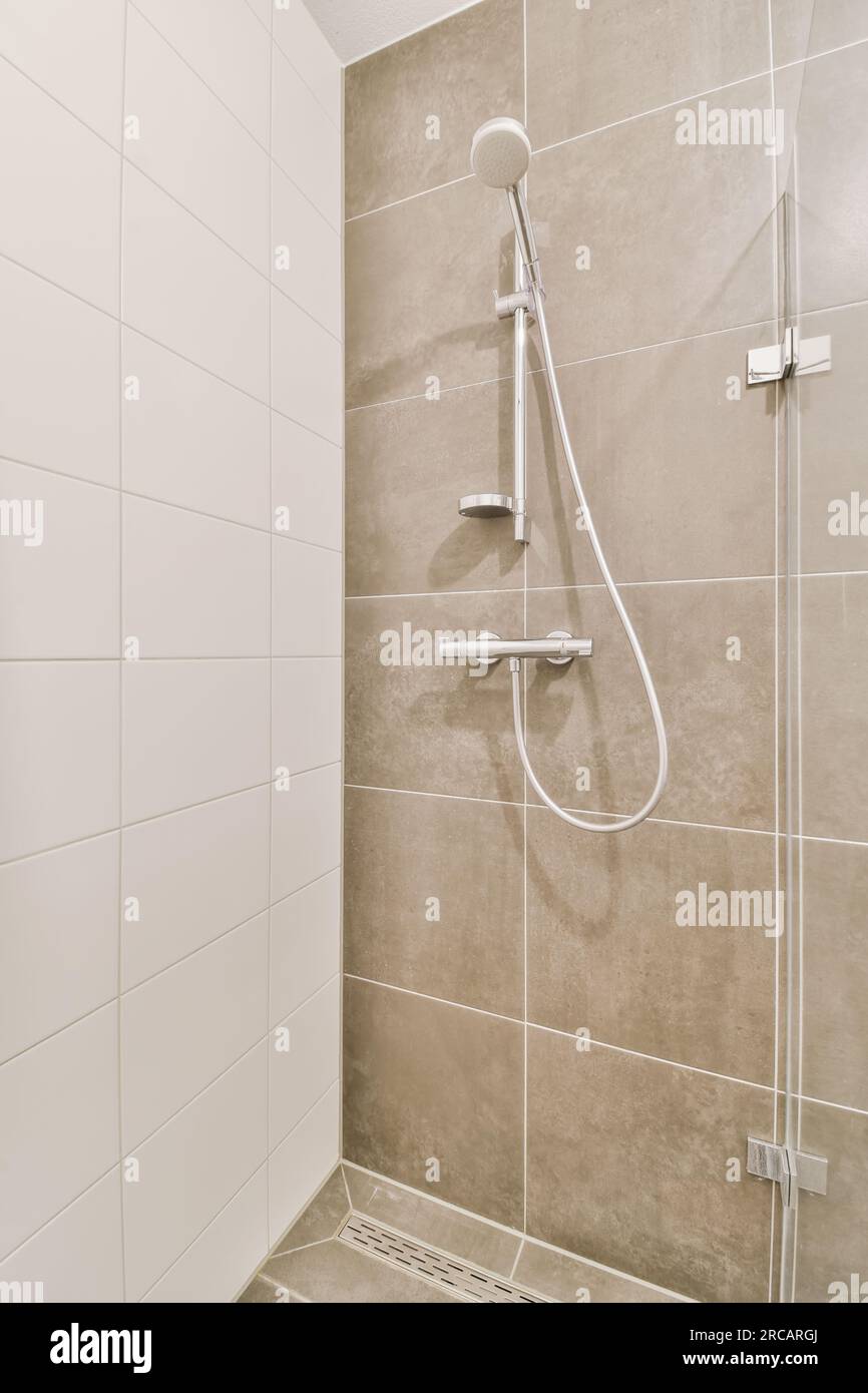 a shower in a bathroom with tiled walls and white tiles on the wall ...