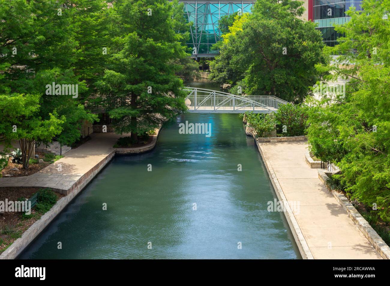 San Antonio, Texas, USA – May 8, 2023: Scenic view of the San Antonio River Walk with green trees in downtown San Antonio, Texas. Stock Photo