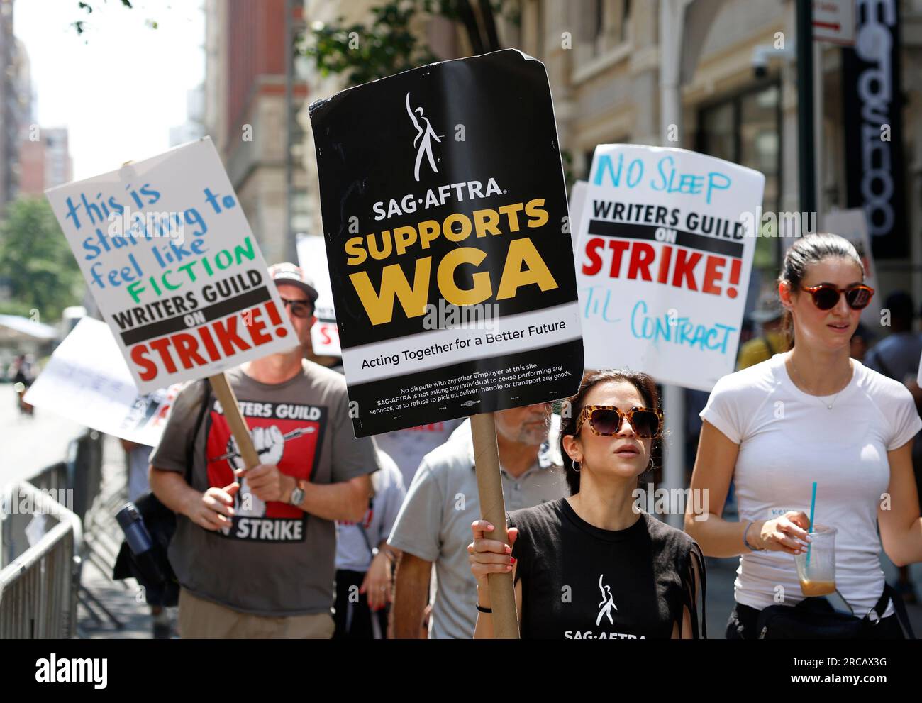 New York, United States. 13th July, 2023. Members of the Writers Guild of America East are joined by SAG-AFTRA members as they both hold up signs picketing outside of the Warner Bros. Discovery office on Thursday July 13, 2023 in New York City. SAG-AFTRA representing 160,000 television and movie actors are set to strike joining screenwriters who have been picketing since May due to a range of issues including pay and the use of artificial intelligence. Photo by John Angelillo/UPI Credit: UPI/Alamy Live News Stock Photo