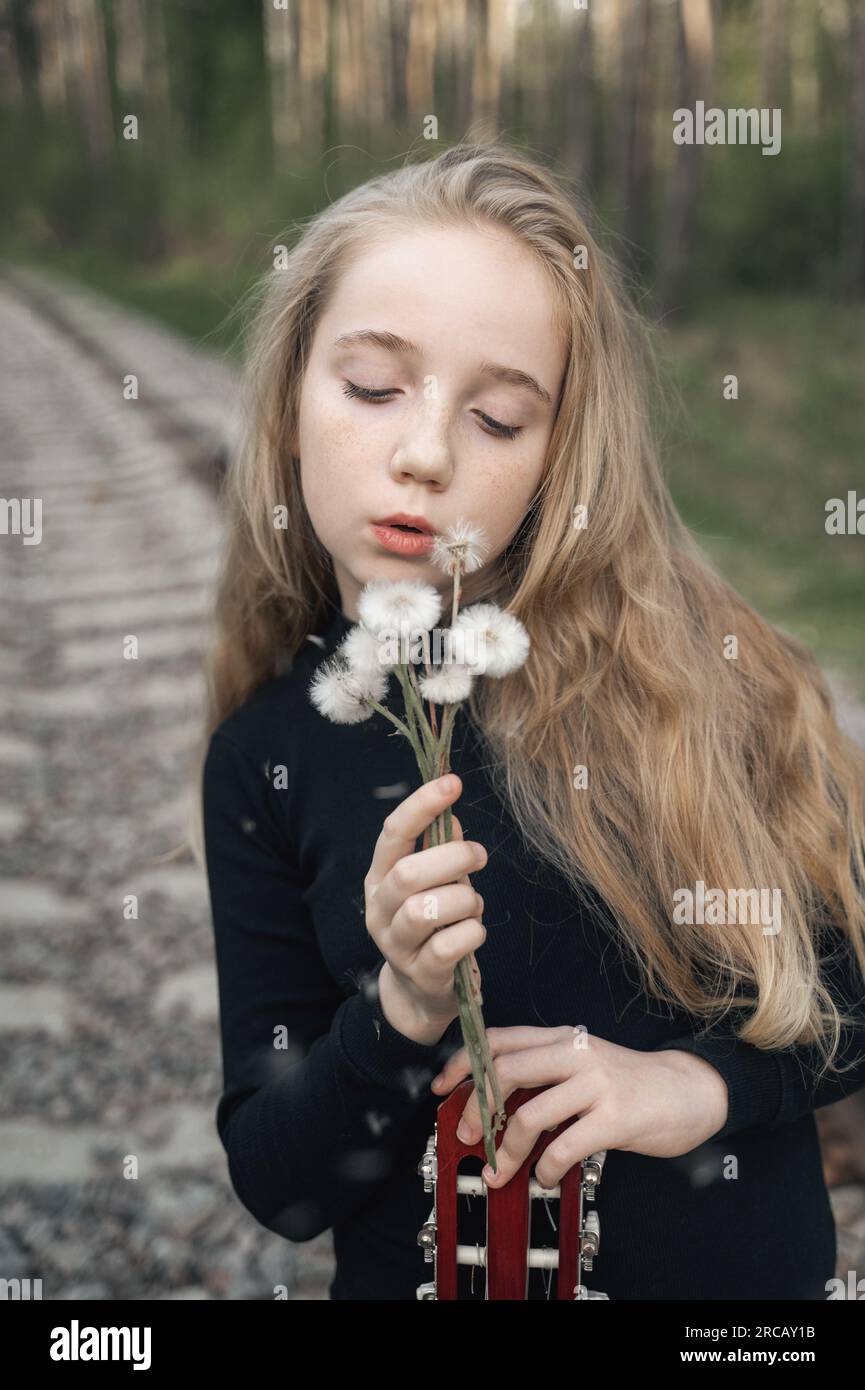 Summer Portrait Of A Romantic Girl Outdoors With Big Fluffy Dandelions summer-portrait-of-a-romantic-girl-outdoors-with-big-fluffy-dandelions