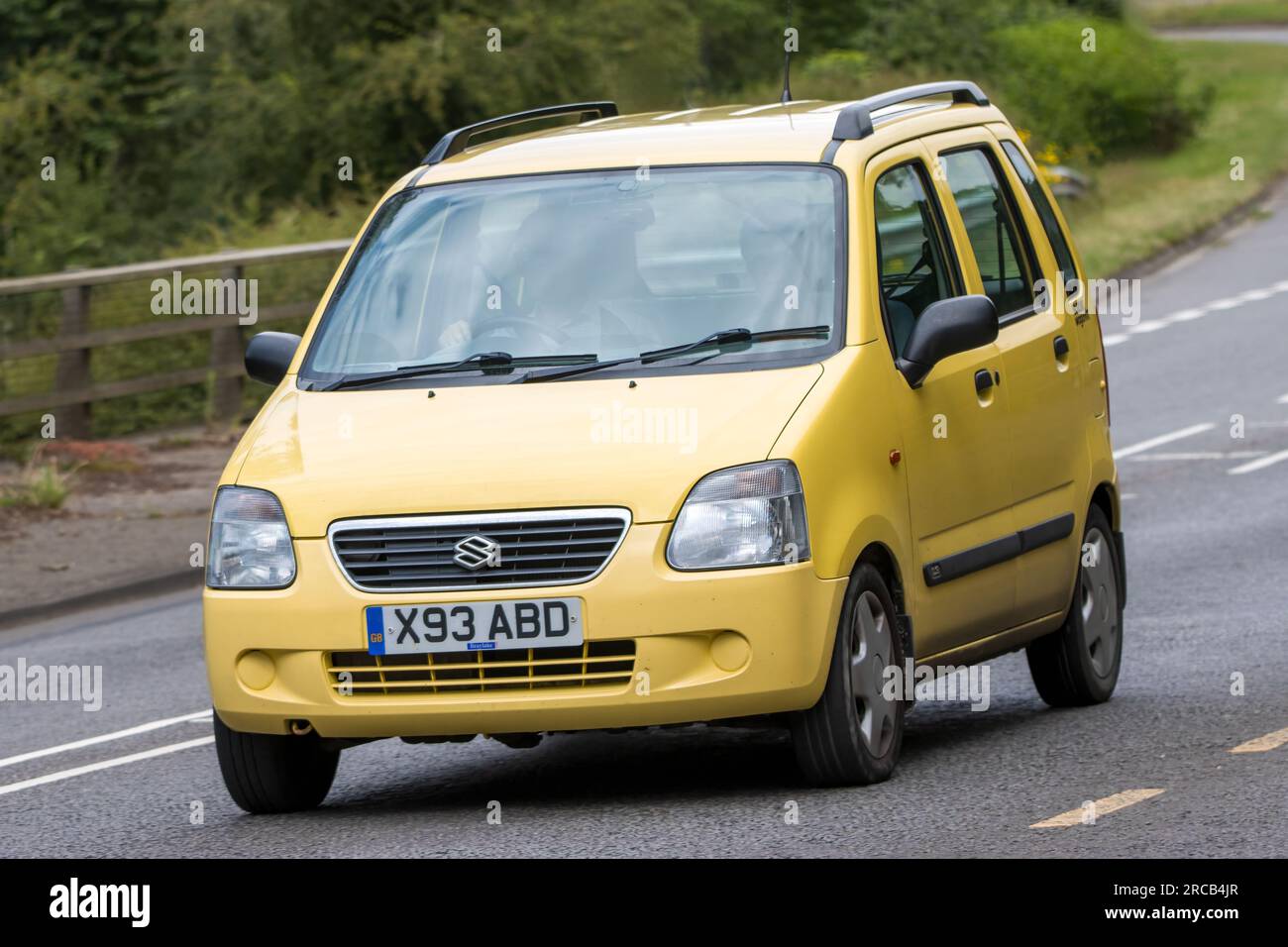 Milton Keynes,UK - July 13th 2023: 2000 yellow SUZUKI WAGON-R+  car driving on an English road Stock Photo