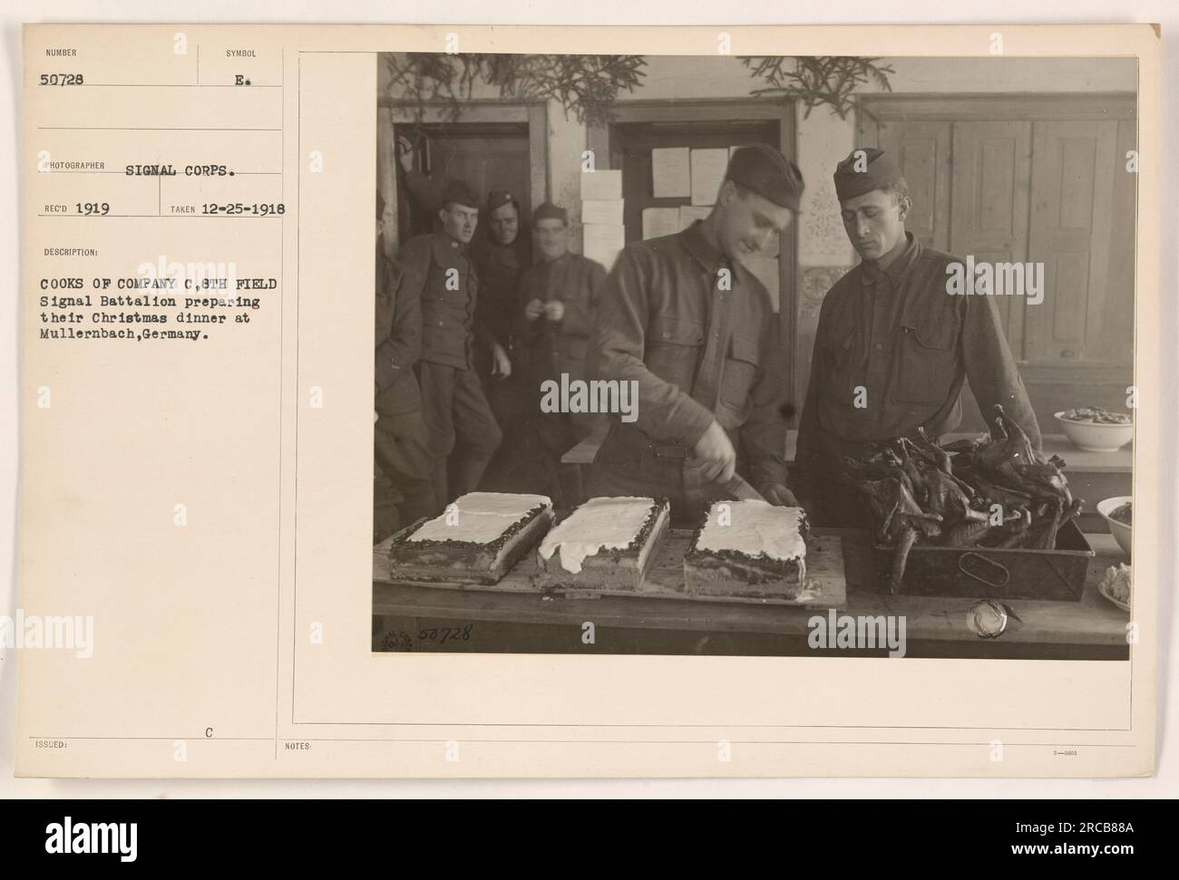 Cooks from Company C, 8th Field Signal Battalion, are seen preparing their Christmas dinner at Mullernbach, Germany. The photograph, taken on 25th December 1918 by the Signal Corps, showcases the soldiers cooking for the festive occasion. The image is labeled as number 50728 in the series. Stock Photo
