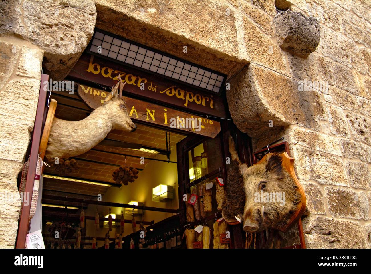 Entrance of sausage shop, stuffed boar head, stuffed deer head, San Gimignano, Tuscany, hunting trophy, trophy, Italy Stock Photo