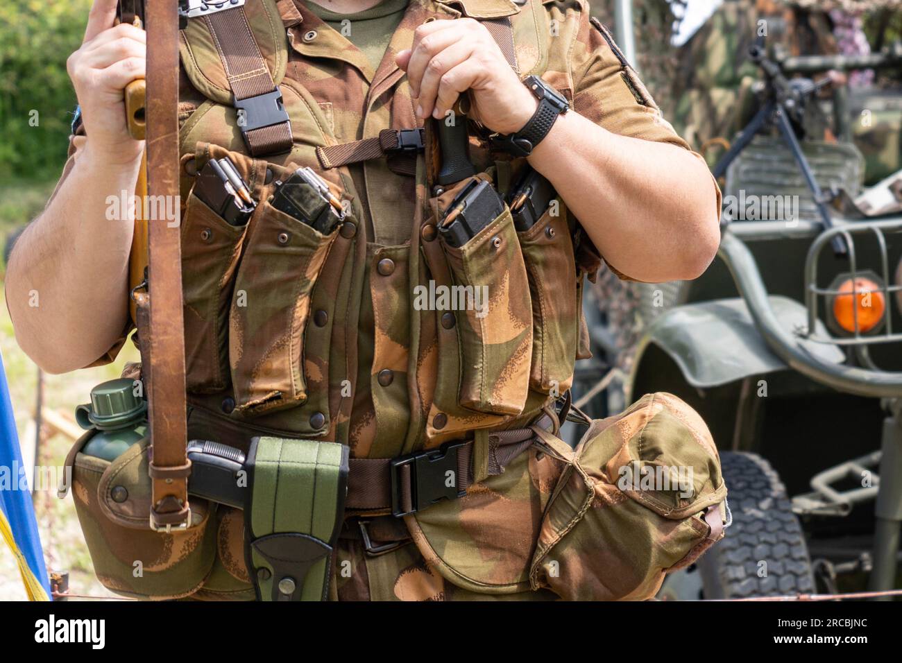 Soldier in camouflage military gear with AK-47 Kalashnikov assault rifle with magazines Stock Photo