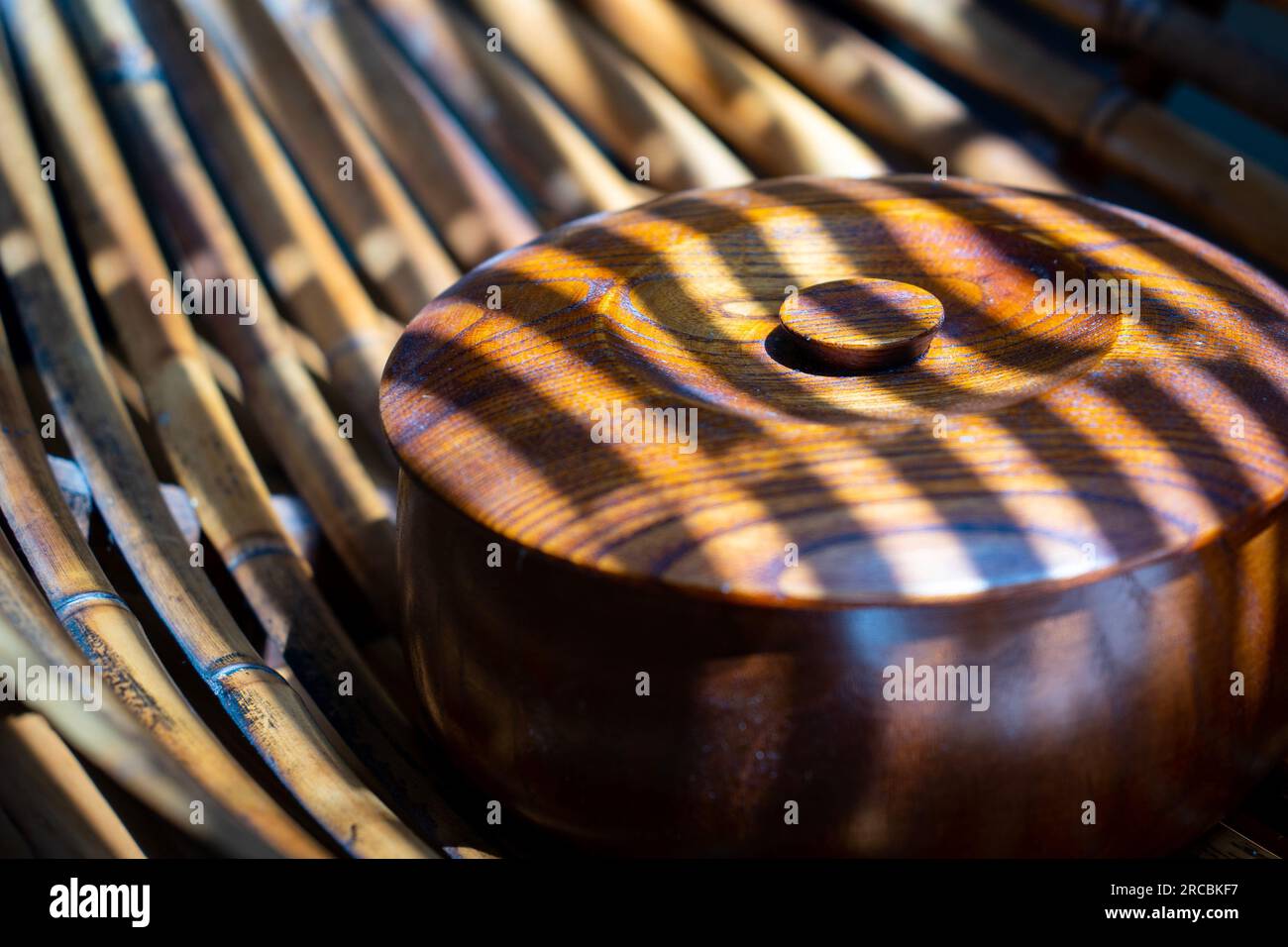 Brown round wood-patterned box in the light filtering through the blinds  Stock Photo - Alamy