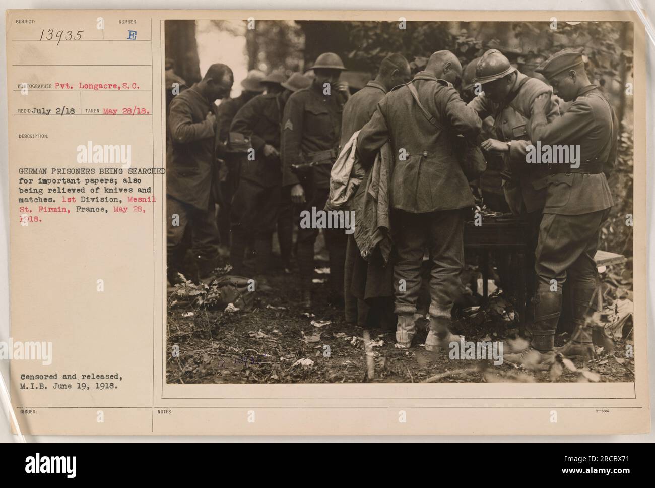 German prisoners being searched for documents and confiscated of knives and matches by American soldiers. Taken in Mesnil St. Pirmin, France, on May 28, 1918, by Pvt. Longacre, S. C. Image subjected to censorship and released by M.I.B on June 19, 1918. Stock Photo