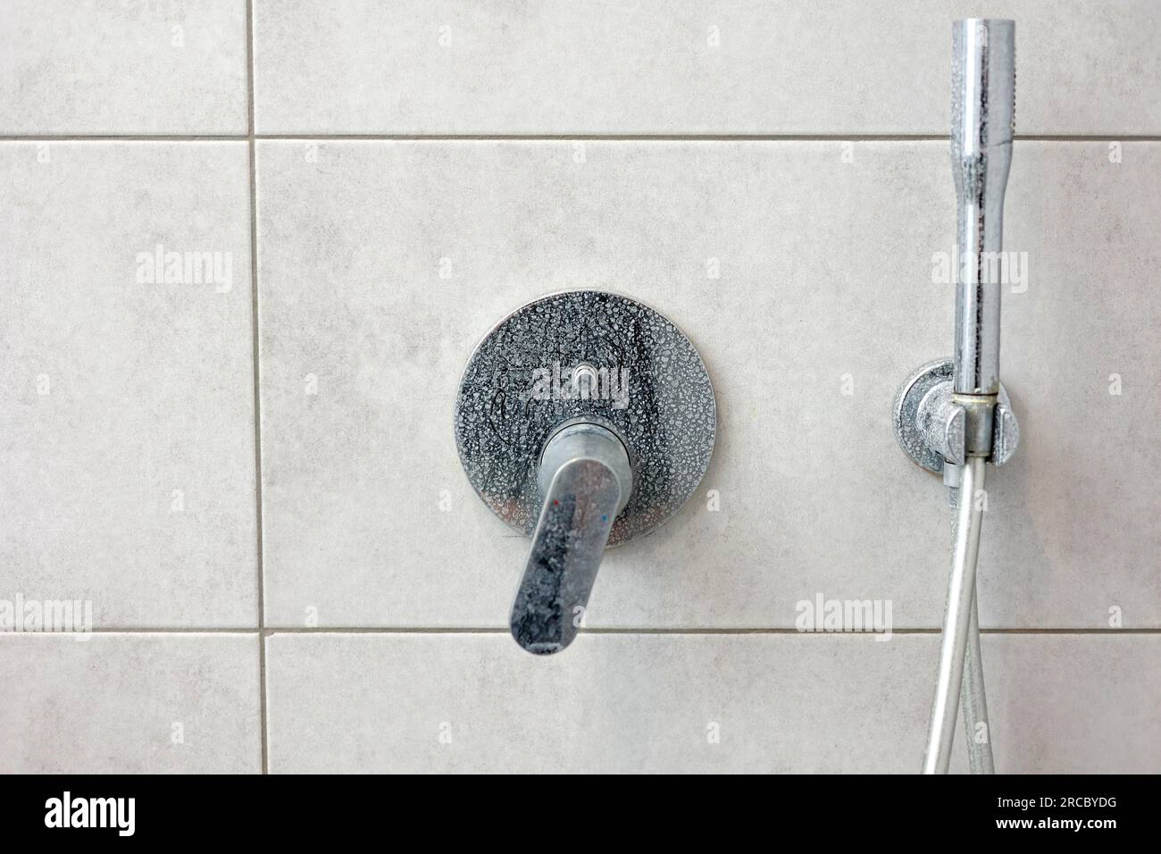 Dirty calcified shower mixer tap, faucet with limescale on it, plaque