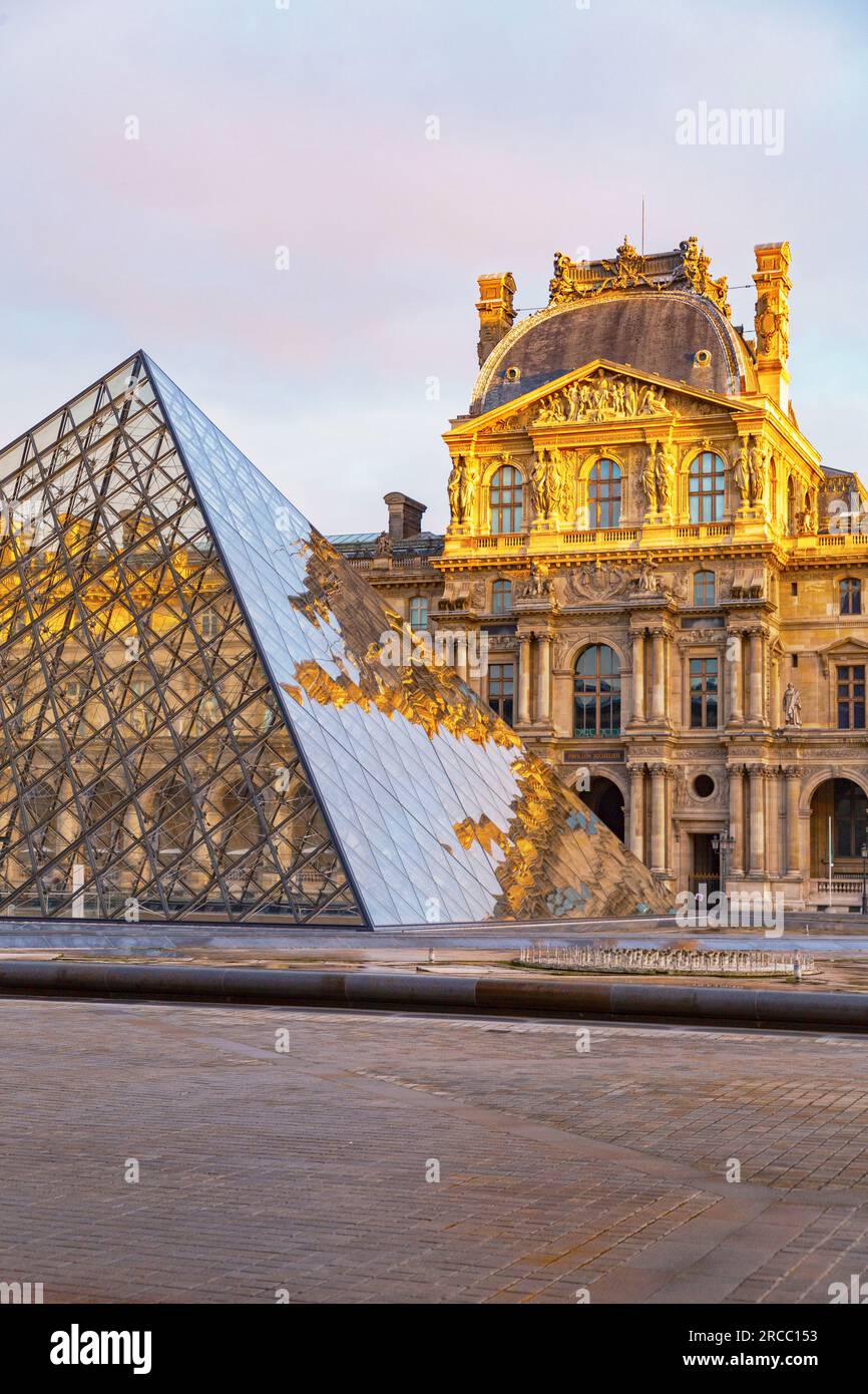 Paris, France - JAN 20, 2022: The glass pyramid of Louvre Museum, the main entrance to famous museum and gallery, completed in 1989. A beautiful winte Stock Photo