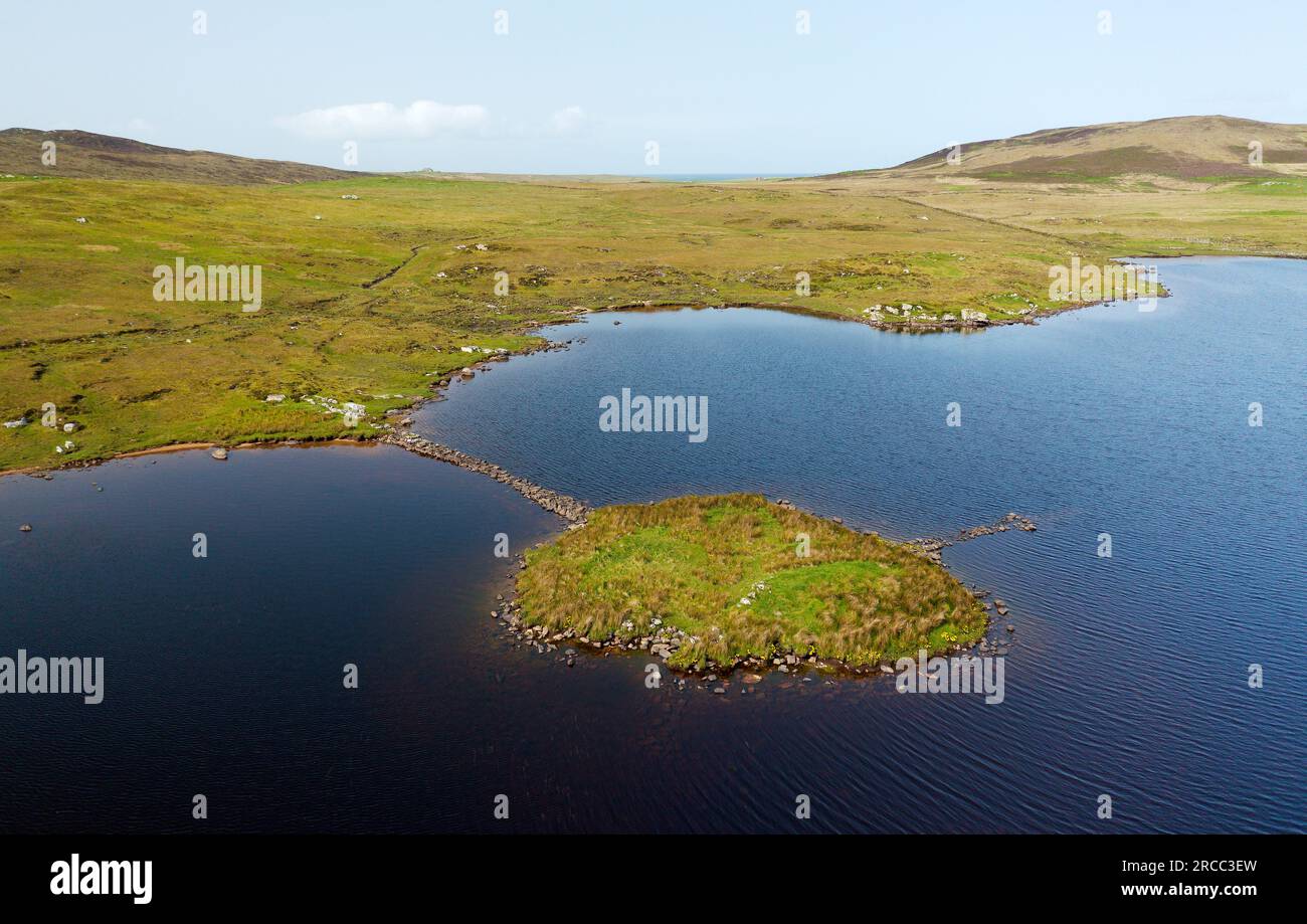 Eilean Domhnuill islet in Loch Olabhat, N. Uist, Scotland. 5000 year prehistoric Neolithic early crannog habitation site showing causeway. View to SW Stock Photo