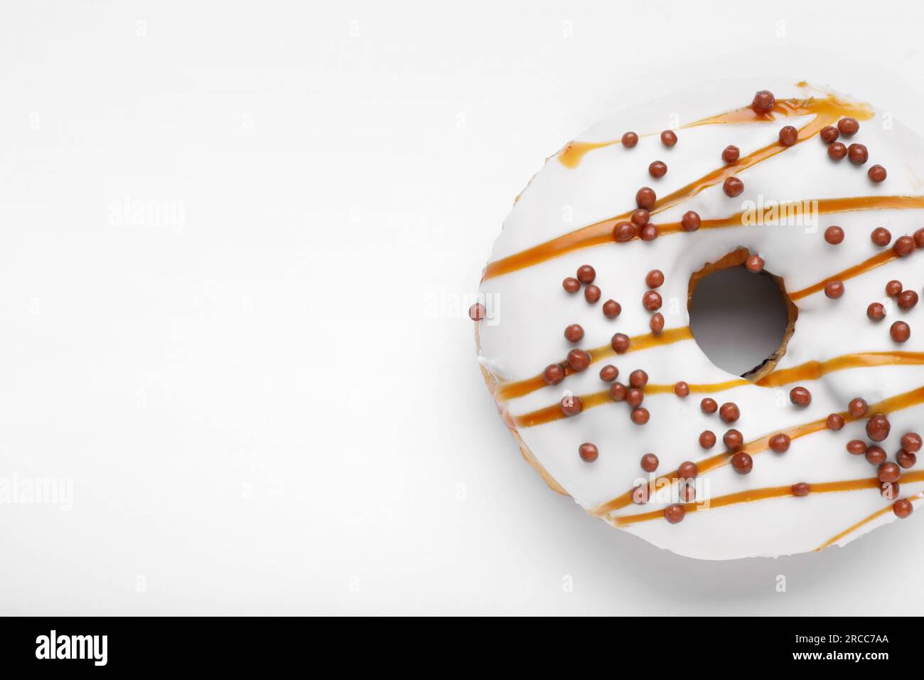 Tasty glazed donut decorated with sprinkles isolated on white, top view ...