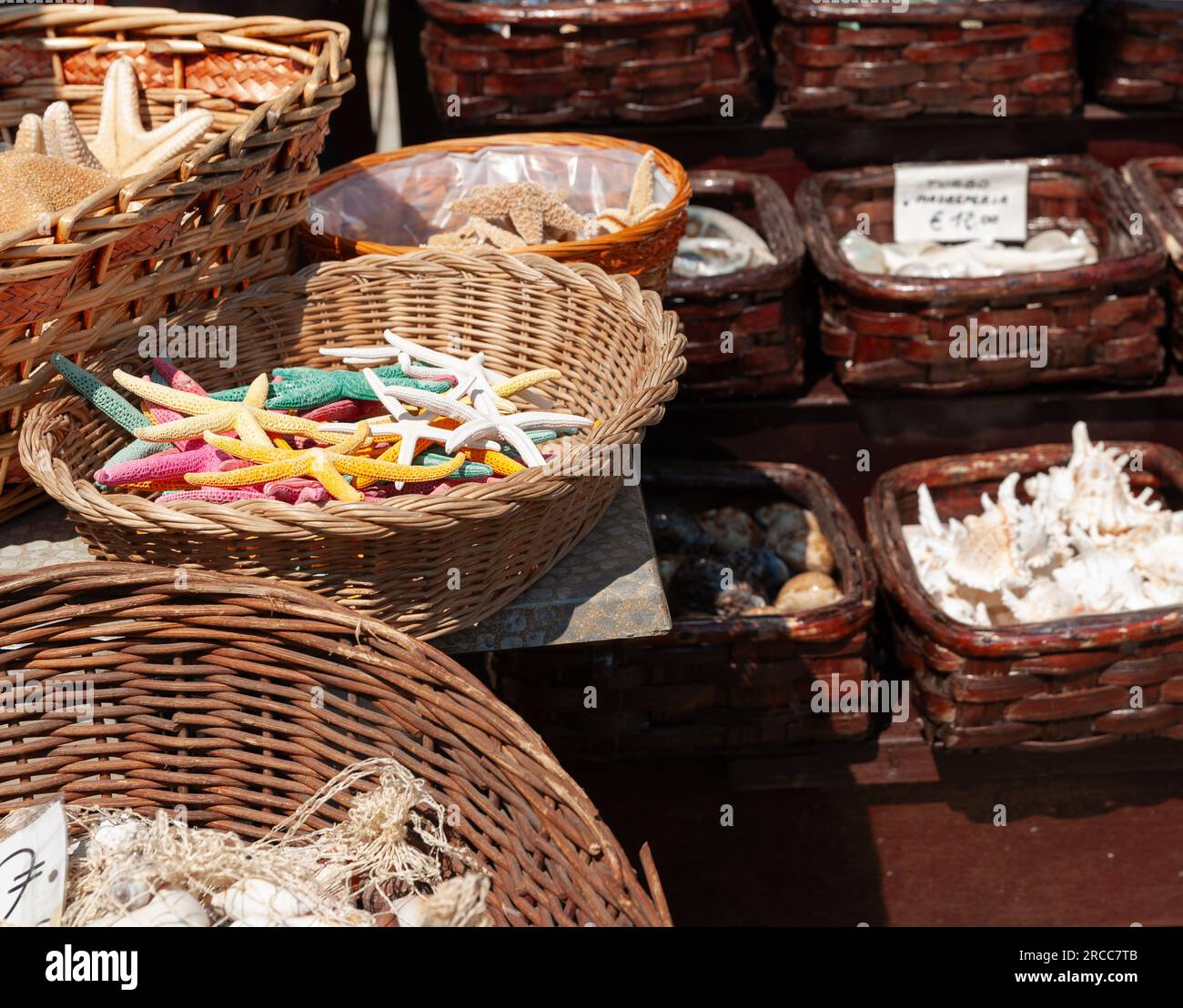 Basket brightly coloured dry starfish for sale as souvenirs in Portovenere. Stock Photo