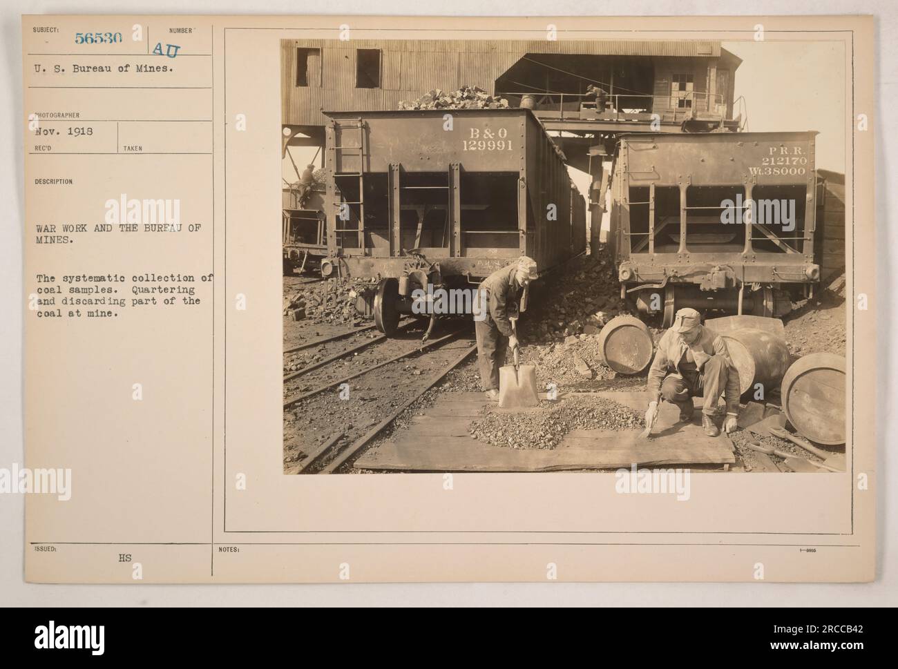 A group of workers at a coal mine can be seen systematically collecting ...