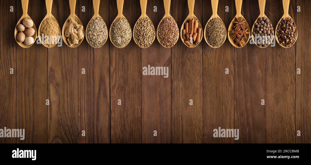 collection  Indian spices in spoons  over wooden table background Stock Photo