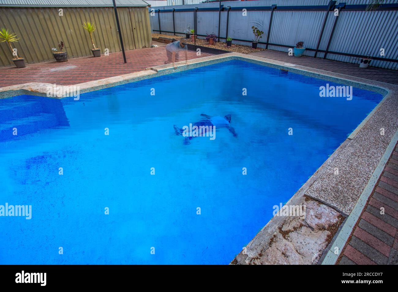 Ghost looking down at themselves in pool Stock Photo
