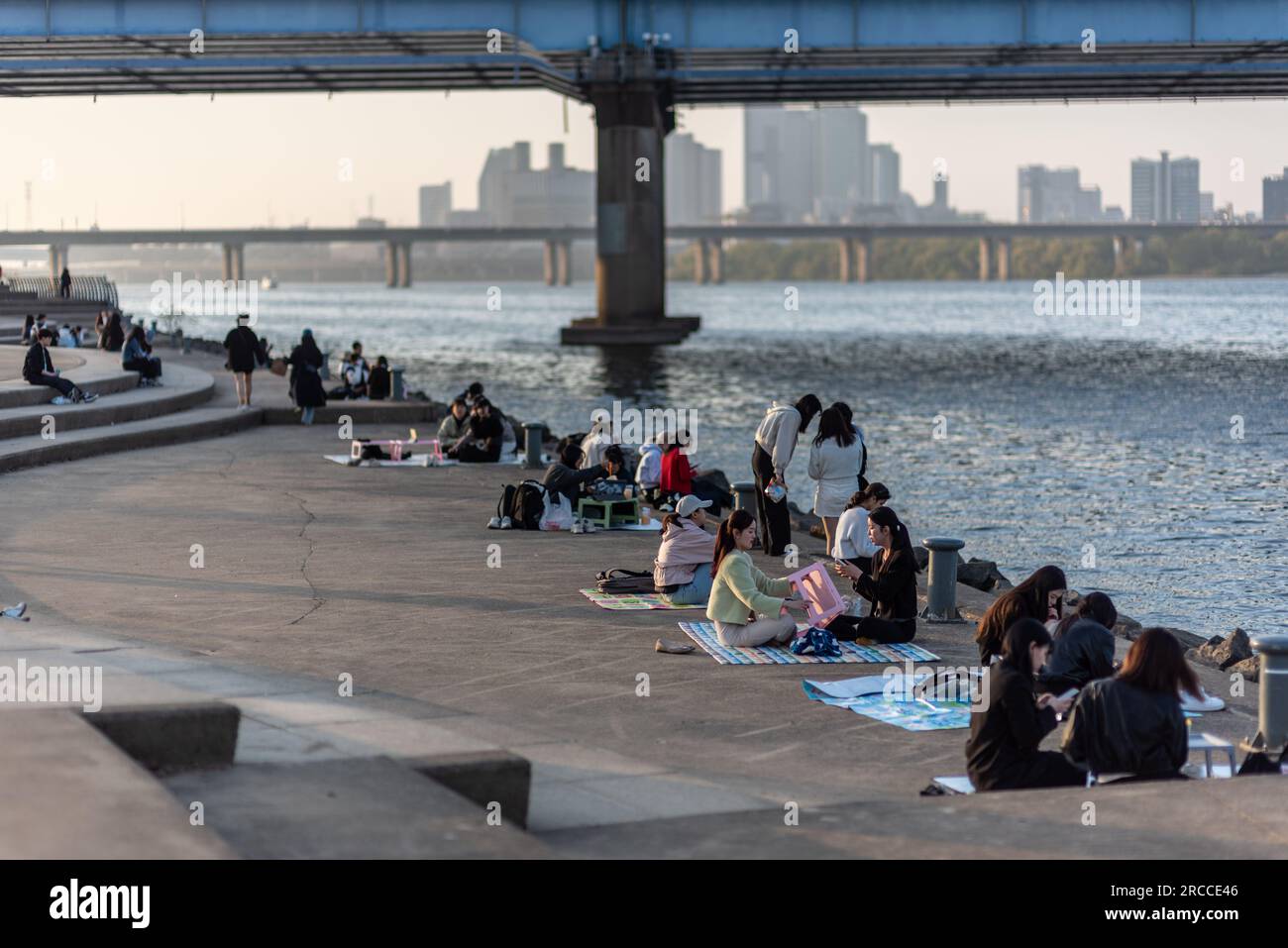People picnicing in Yeouido park on Han river in Seoul, South Korea on 30 March 2023 Stock Photo