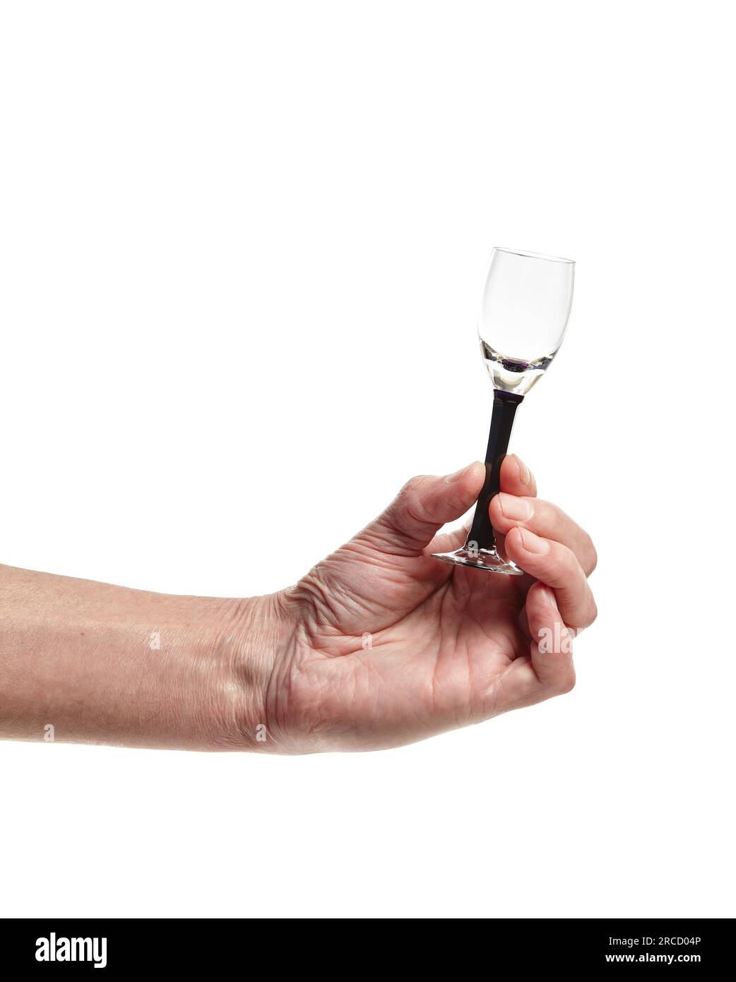 Men's hand holding empty shot glass isolated on a white background. Concept of alcohol, drink, party, degustation, holiday Stock Photo