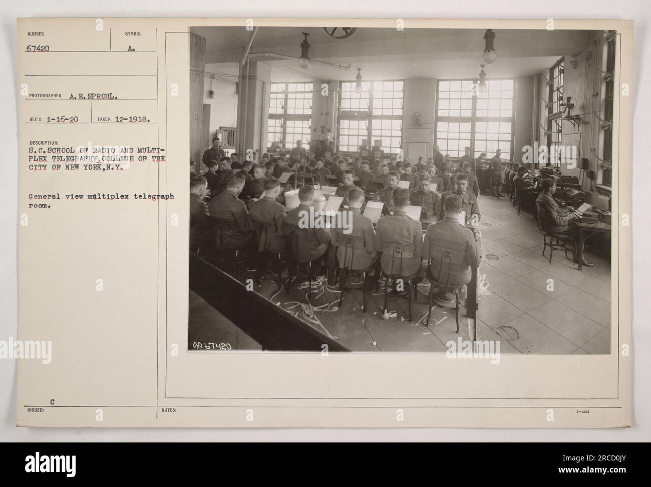 'General view of the multiplex telegraph room at the S.C. School of Radio and Multiplex Telegraphy, part of the College of the City of New York. This photograph, taken in December 1918 by photographer A.E. Sproul, shows a bustling room with multiple operators working the telegraph system.' Stock Photo