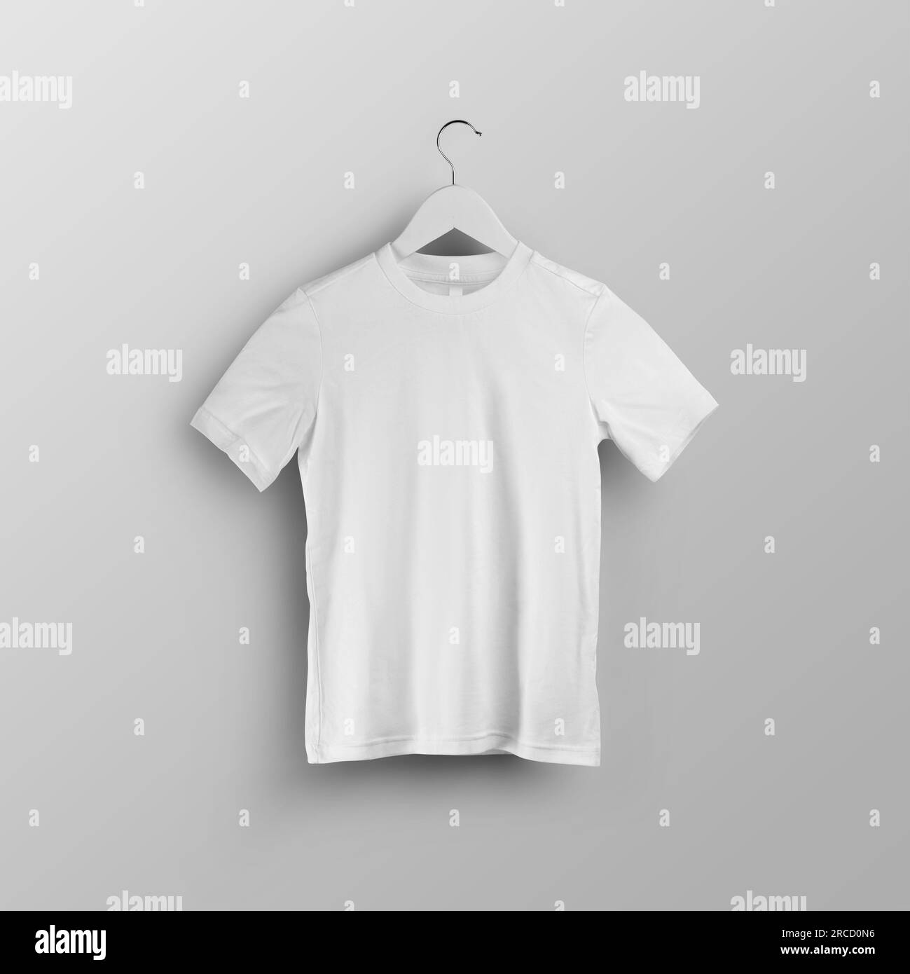 Children's white t-shirt template, blank shirt on hanger, front view, isolated on background. Mockup of stylish kids clothing for design, product phot Stock Photo