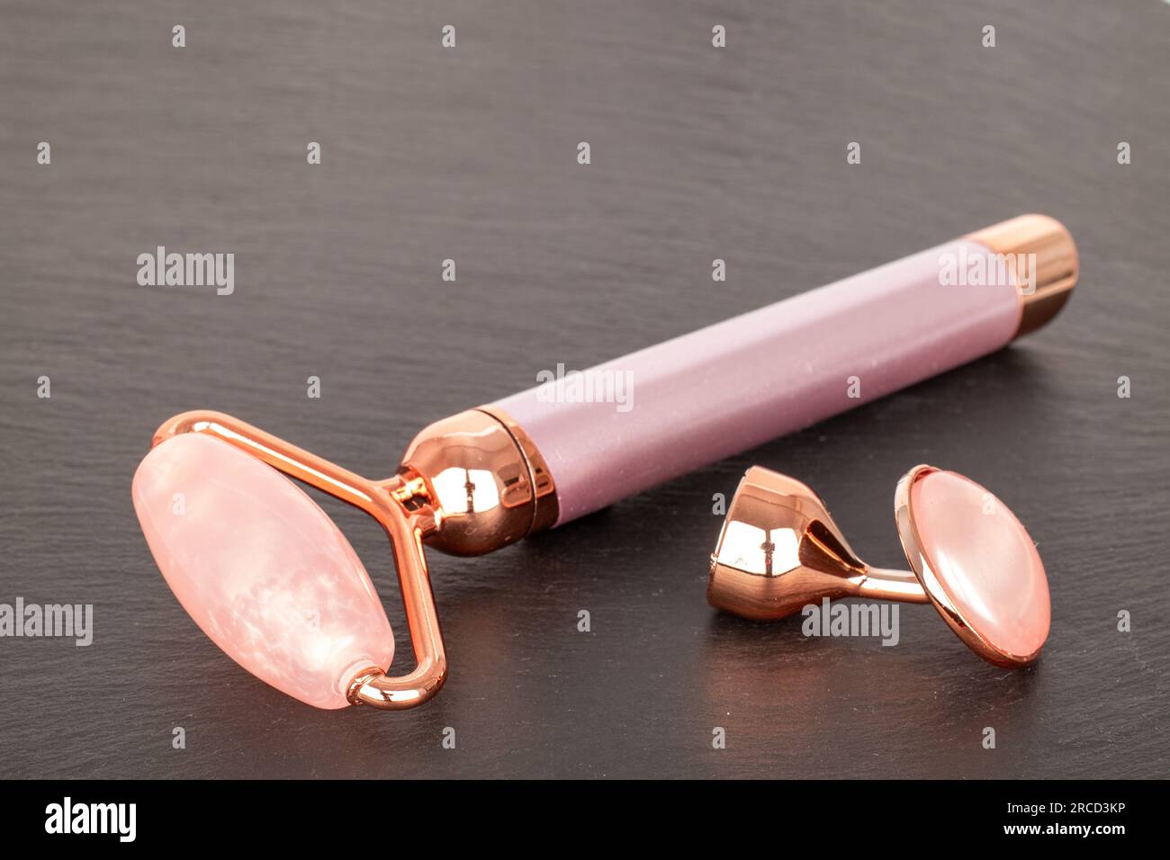 Facial roller, device handle with AA batteries, eye stone on slate