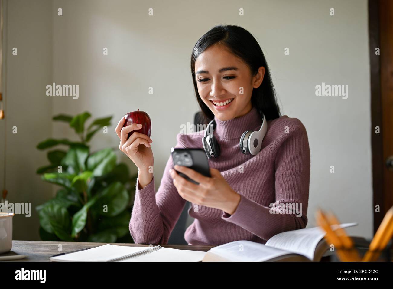 A beautiful Asian woman scrolling on social media on her smartphone ...