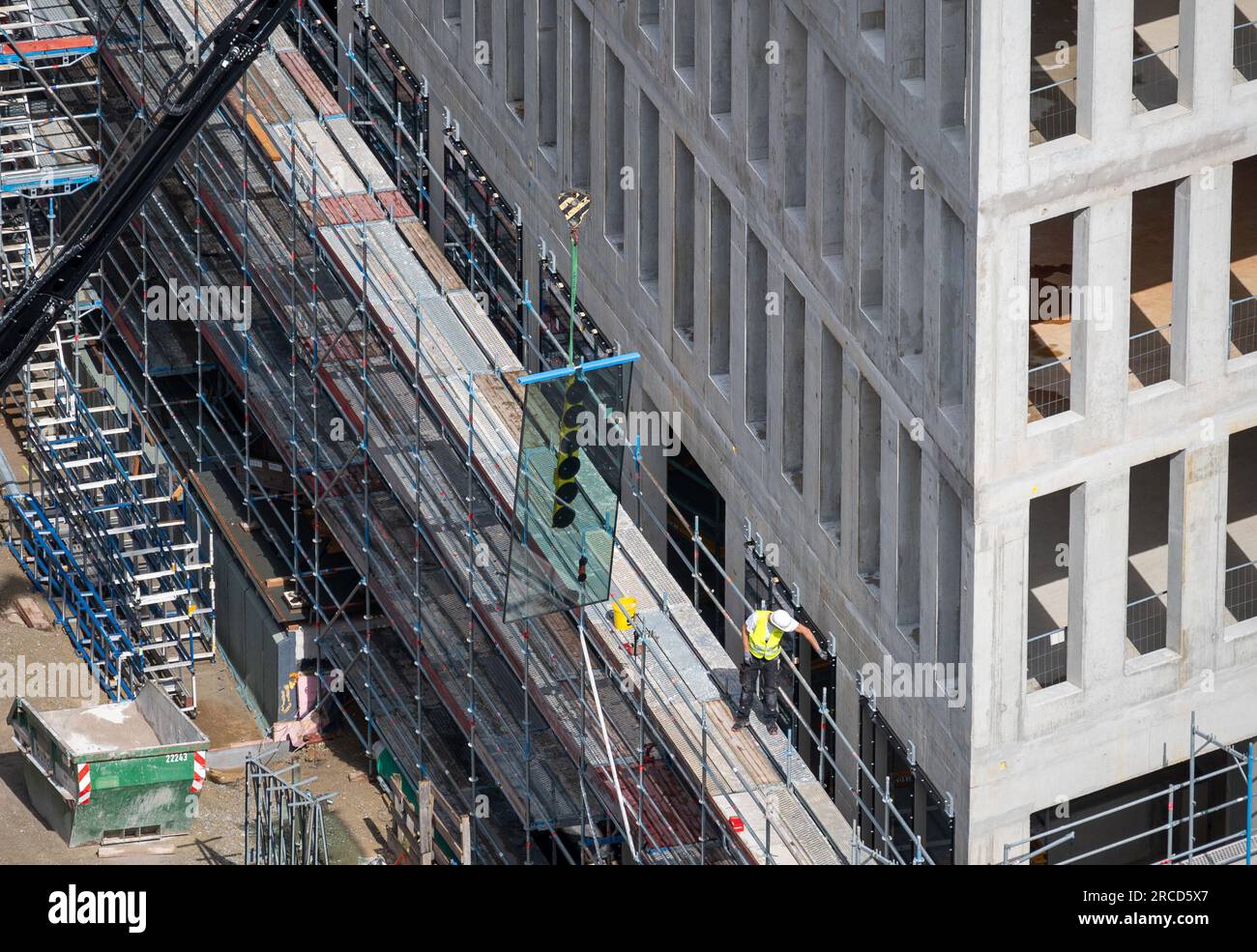 Glazier installing windows on a commercial building. Stock Photo