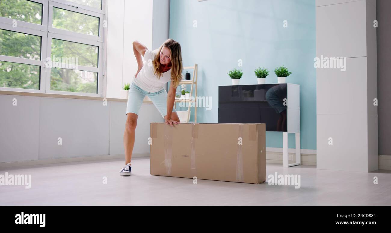 Woman lifting heavy box hi-res stock photography and images - Alamy
