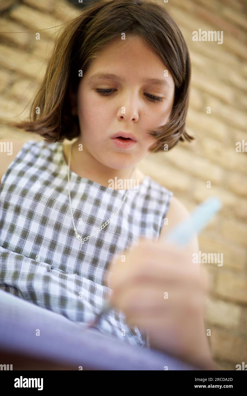 Eight year old girl painting and drawing in a park Stock Photo - Alamy