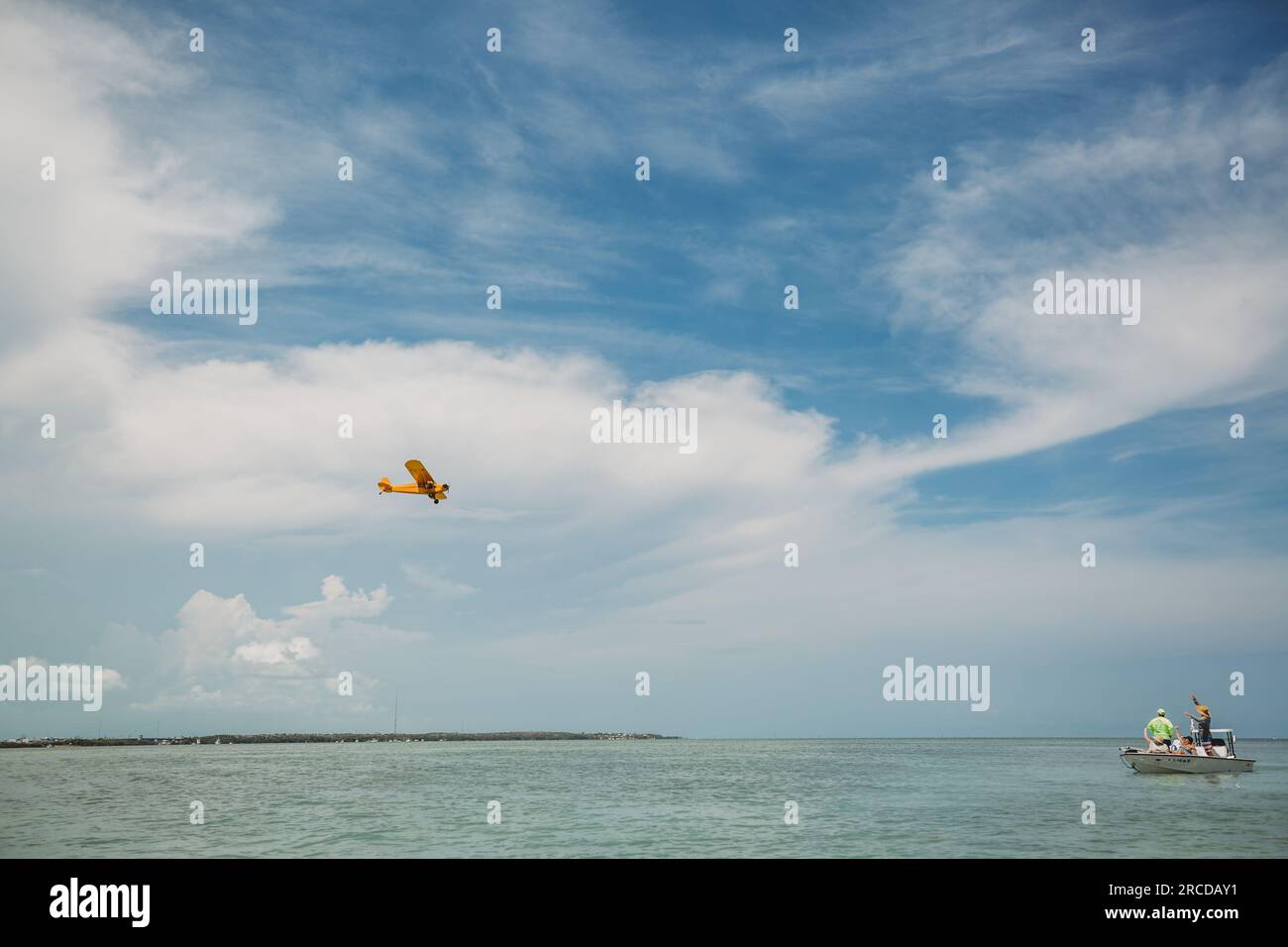 Small plane flies over the water in the Florida Keys Stock Photo