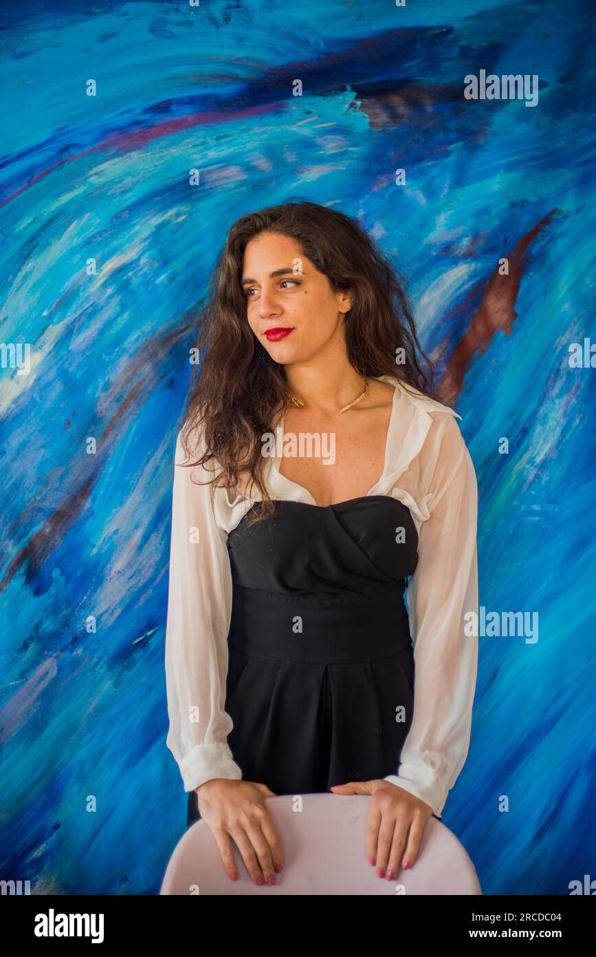 Female painter poses in front of blue painting Stock Photo - Alamy