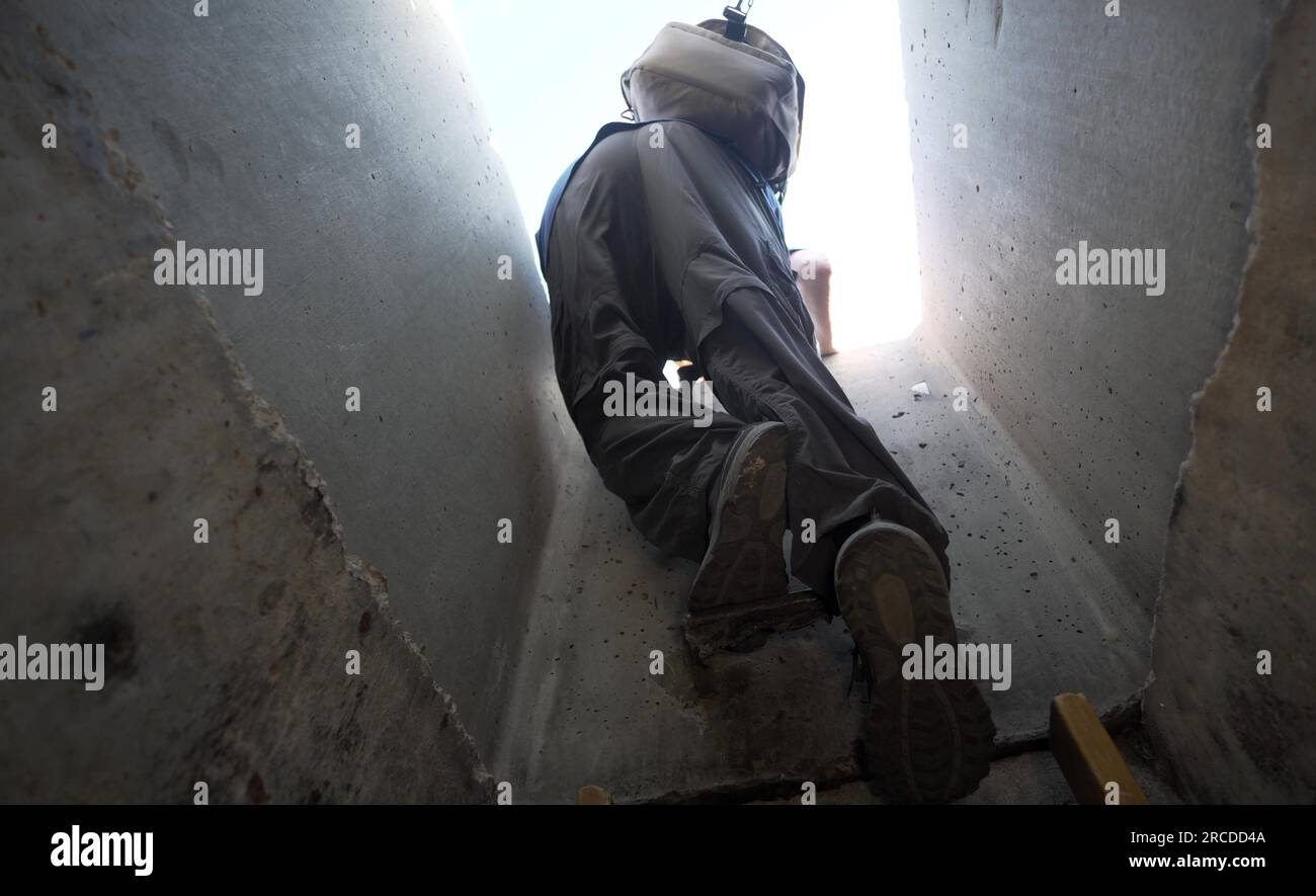 A person climbs out of a tunnel which simulates an underground tunnel ...
