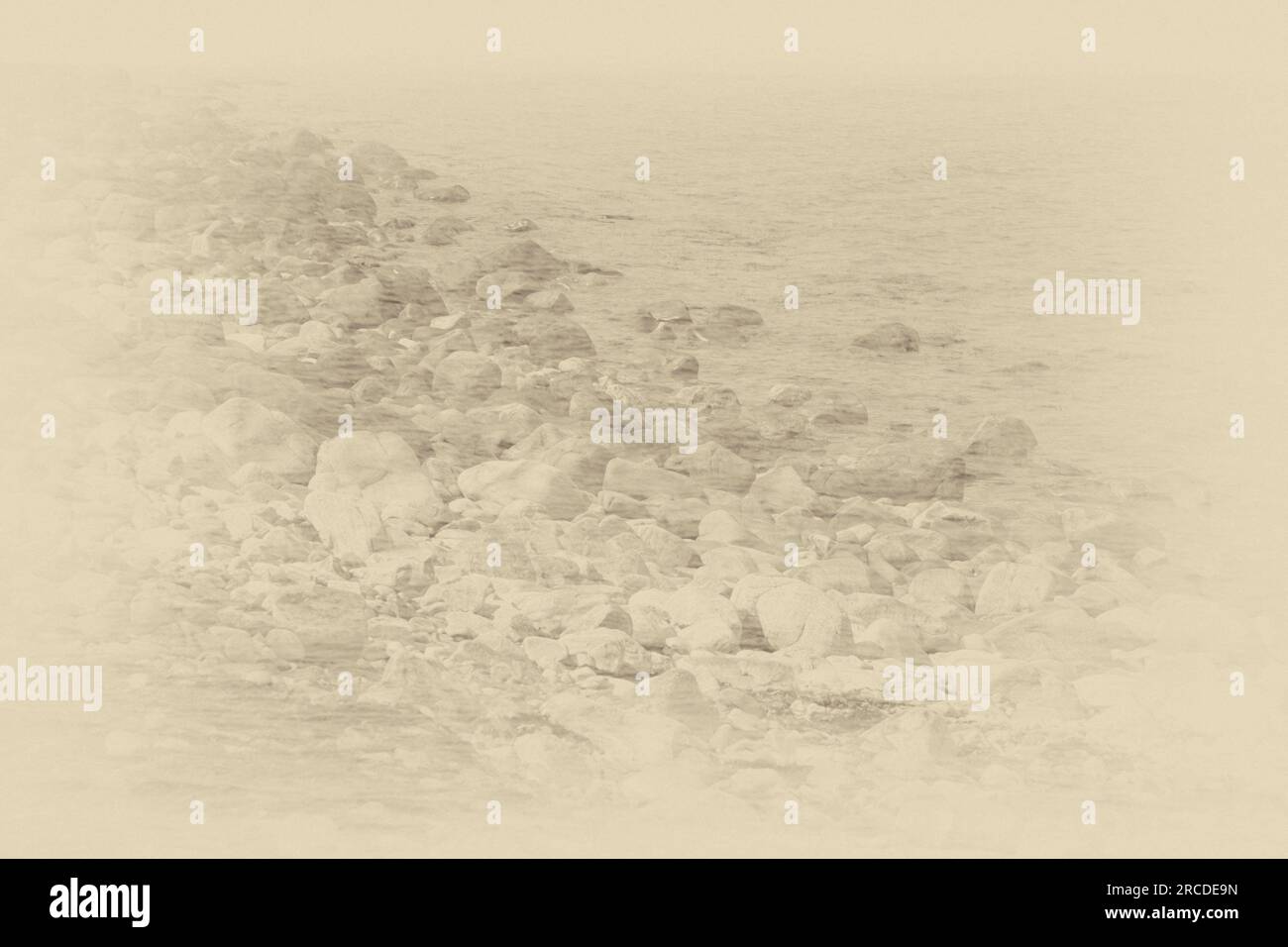 Dreamlike image of rocks by the sea in sepia Stock Photo