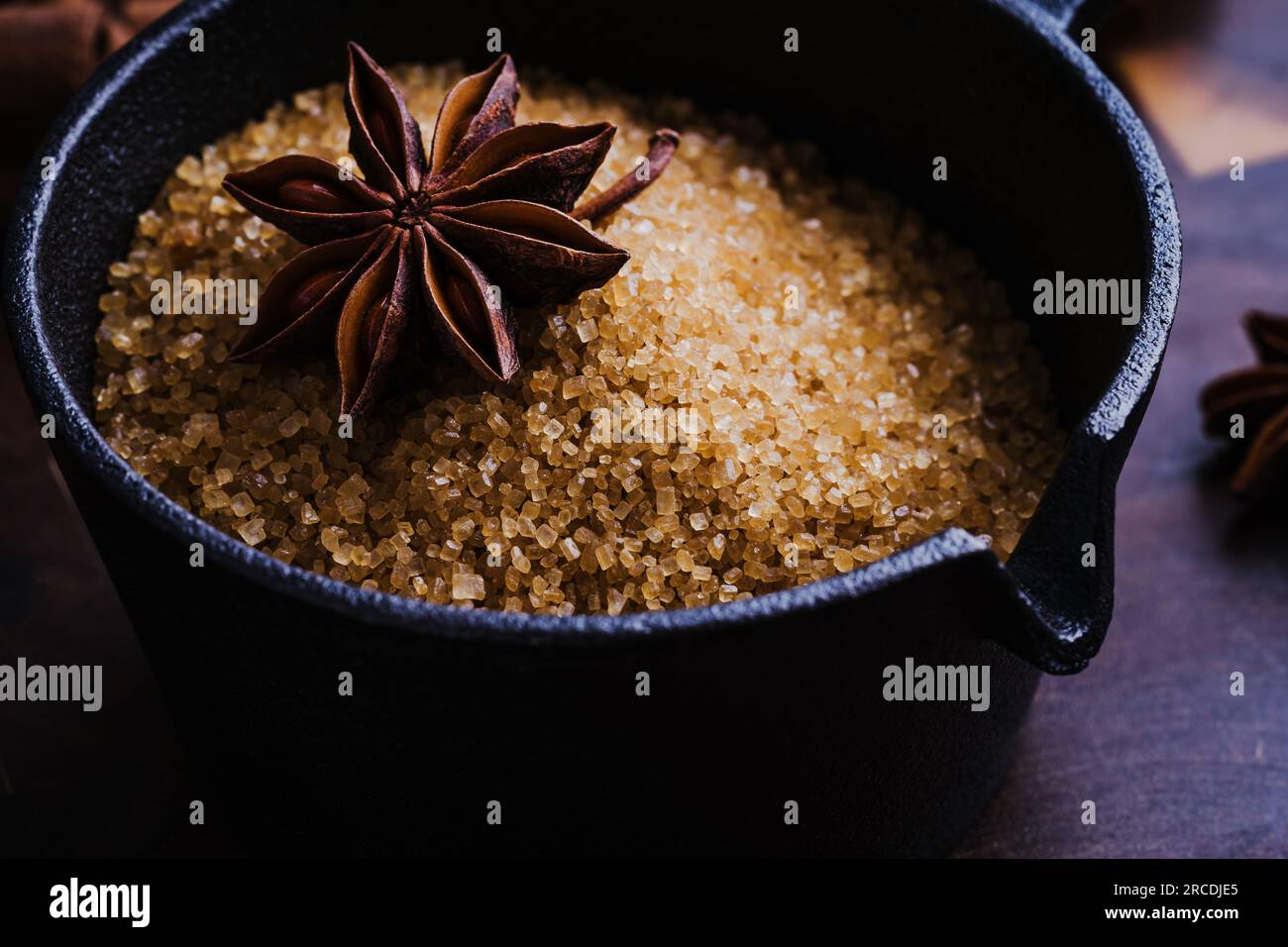 Christmas baking ingredients of gingerbread. Anise and brown sugar in cast iron pan close up Stock Photo