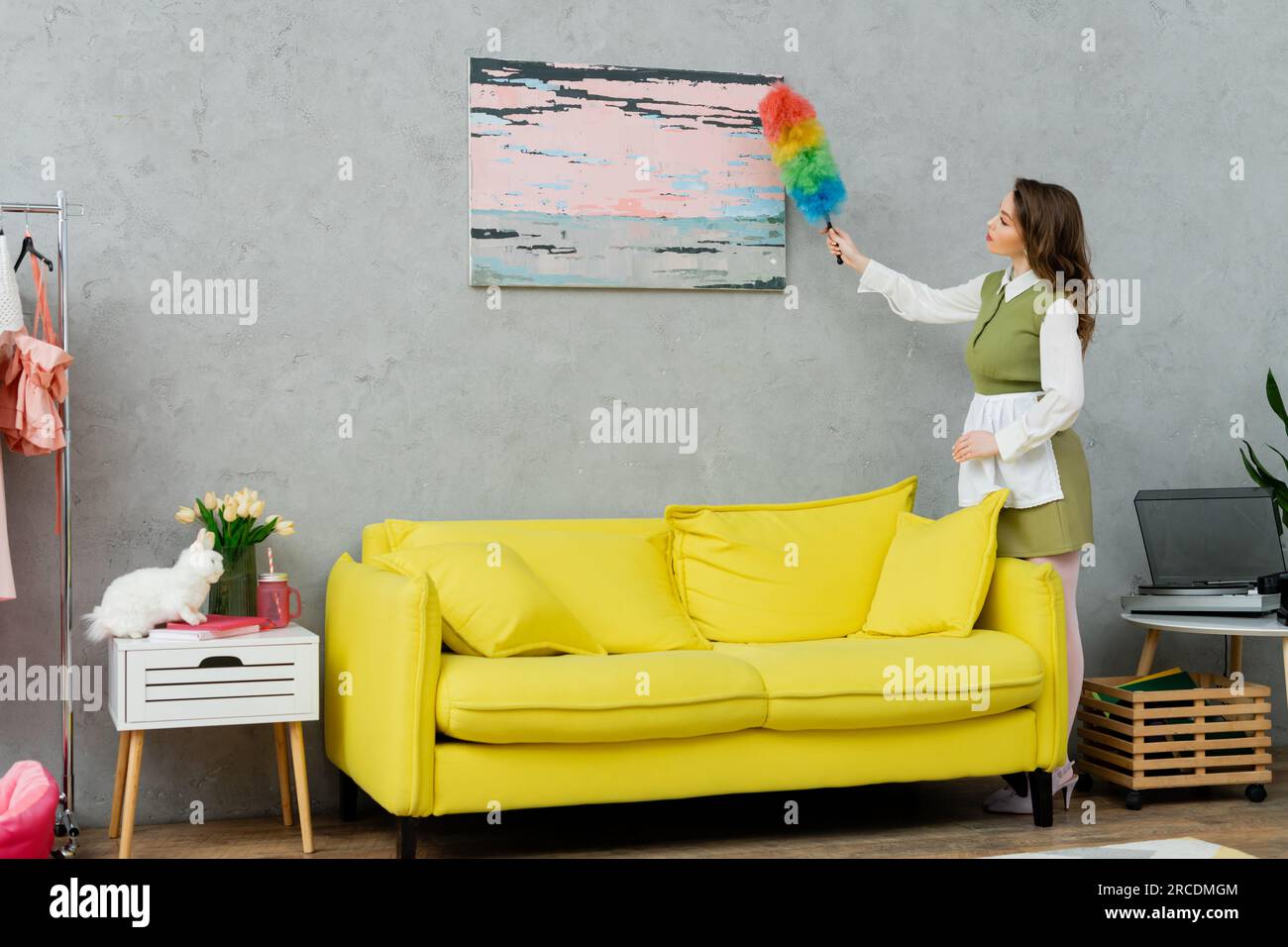 housekeeping concept, young woman with wavy hair cleaning dust
