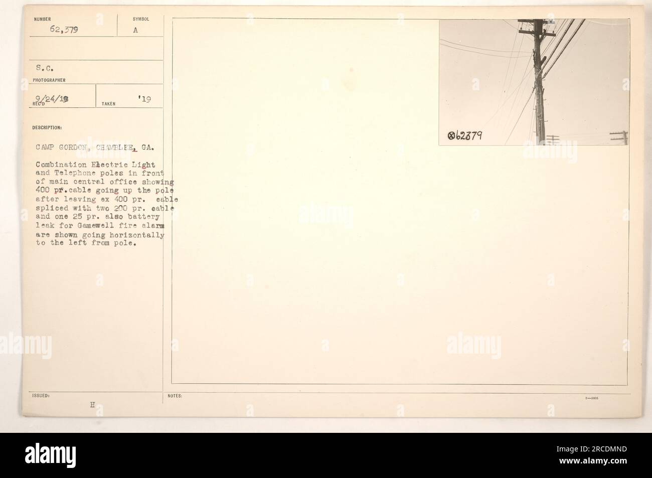 A photograph of combination electric light and telephone poles in front