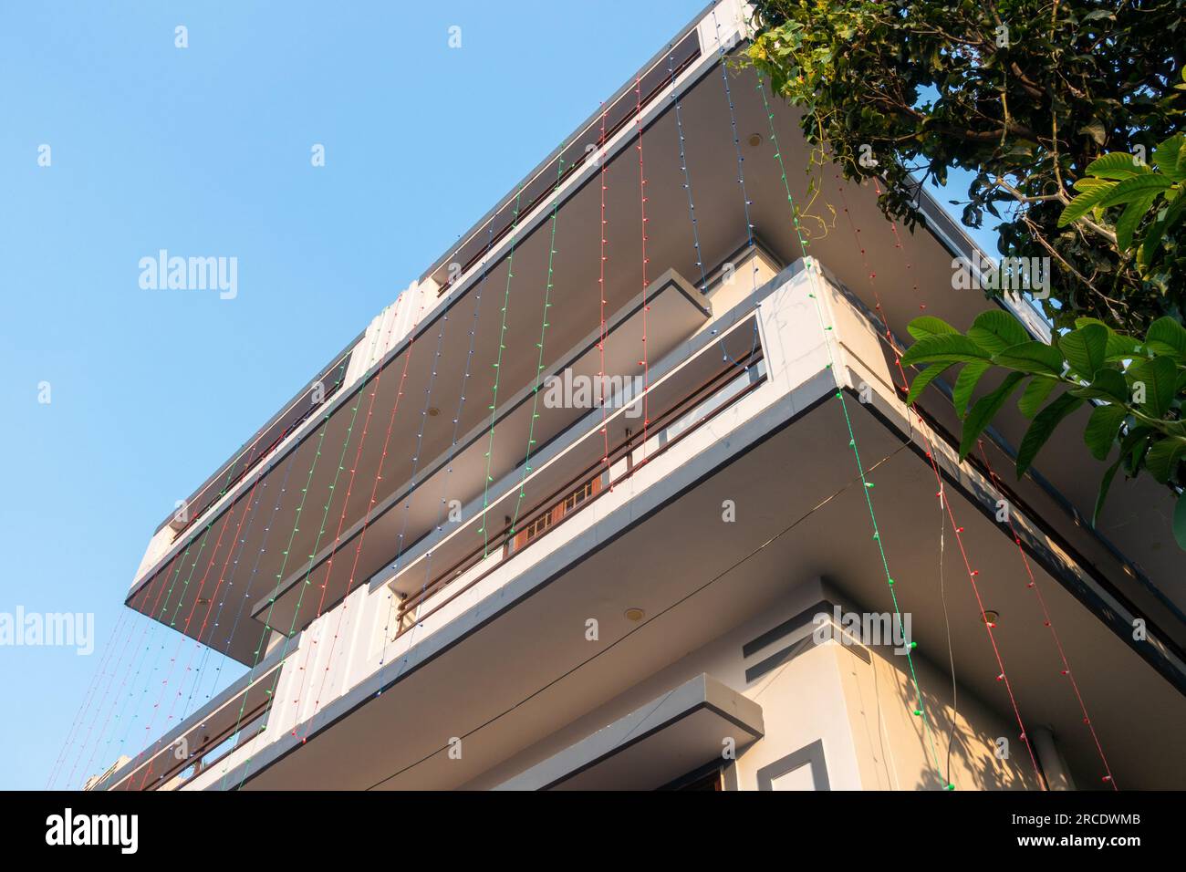 June 28th 2023, Dehradun Uttarakhand, India. Hanging multicolor led light lines from a roof top of an Indian House for decoration. Stock Photo