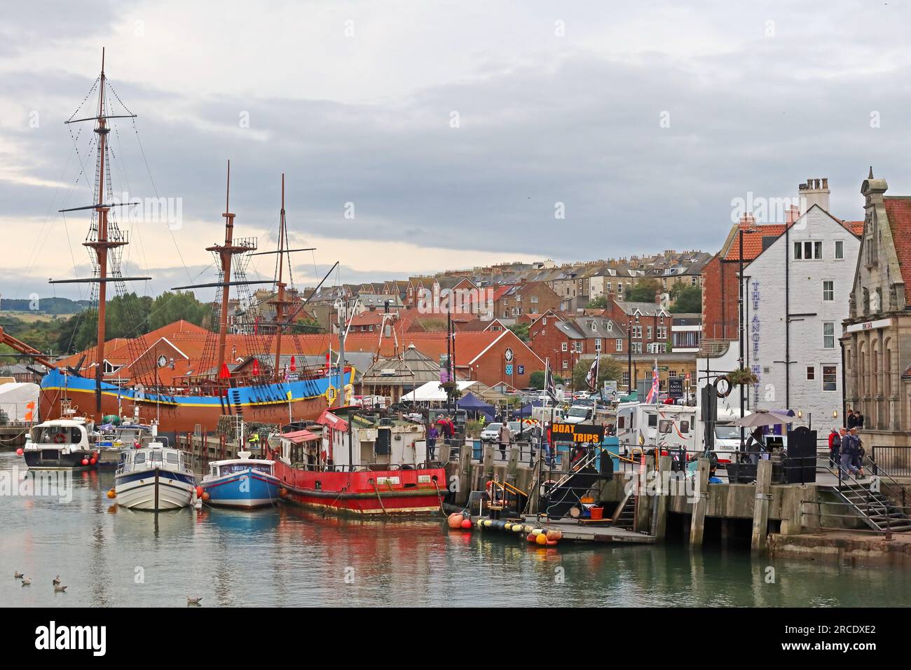 Boats and quayside activity in Whitby Harbour during the summer tourist season, Whitby, North Yorkshire, England, UK Stock Photo